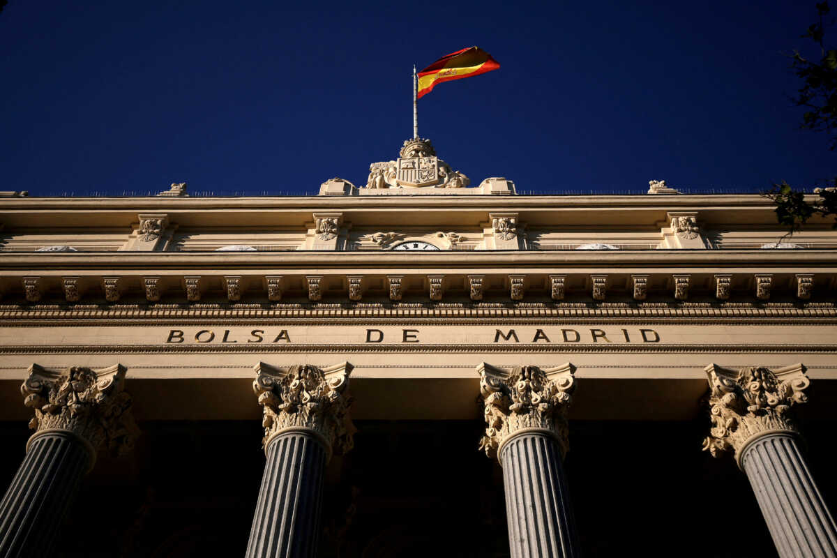 FILE PHOTO: A Spanish flag flutters above the Madrid Stock Exchange, Spain, June 1, 2016. REUTERS
