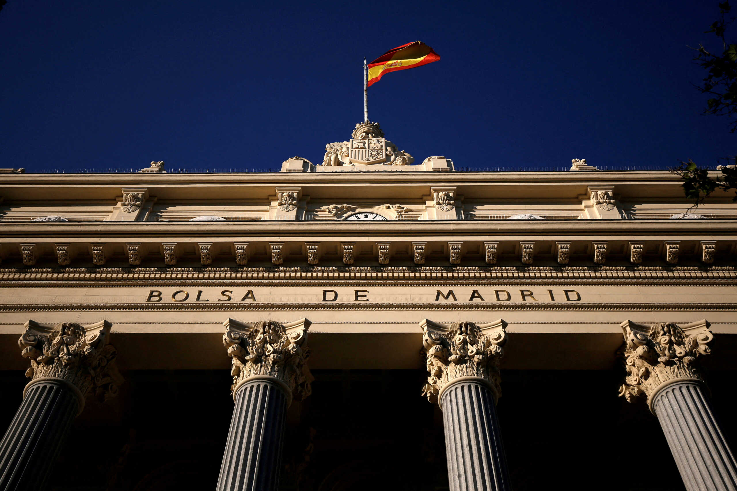 FILE PHOTO: A Spanish flag flutters above the Madrid Stock Exchange, Spain, June 1, 2016. REUTERS