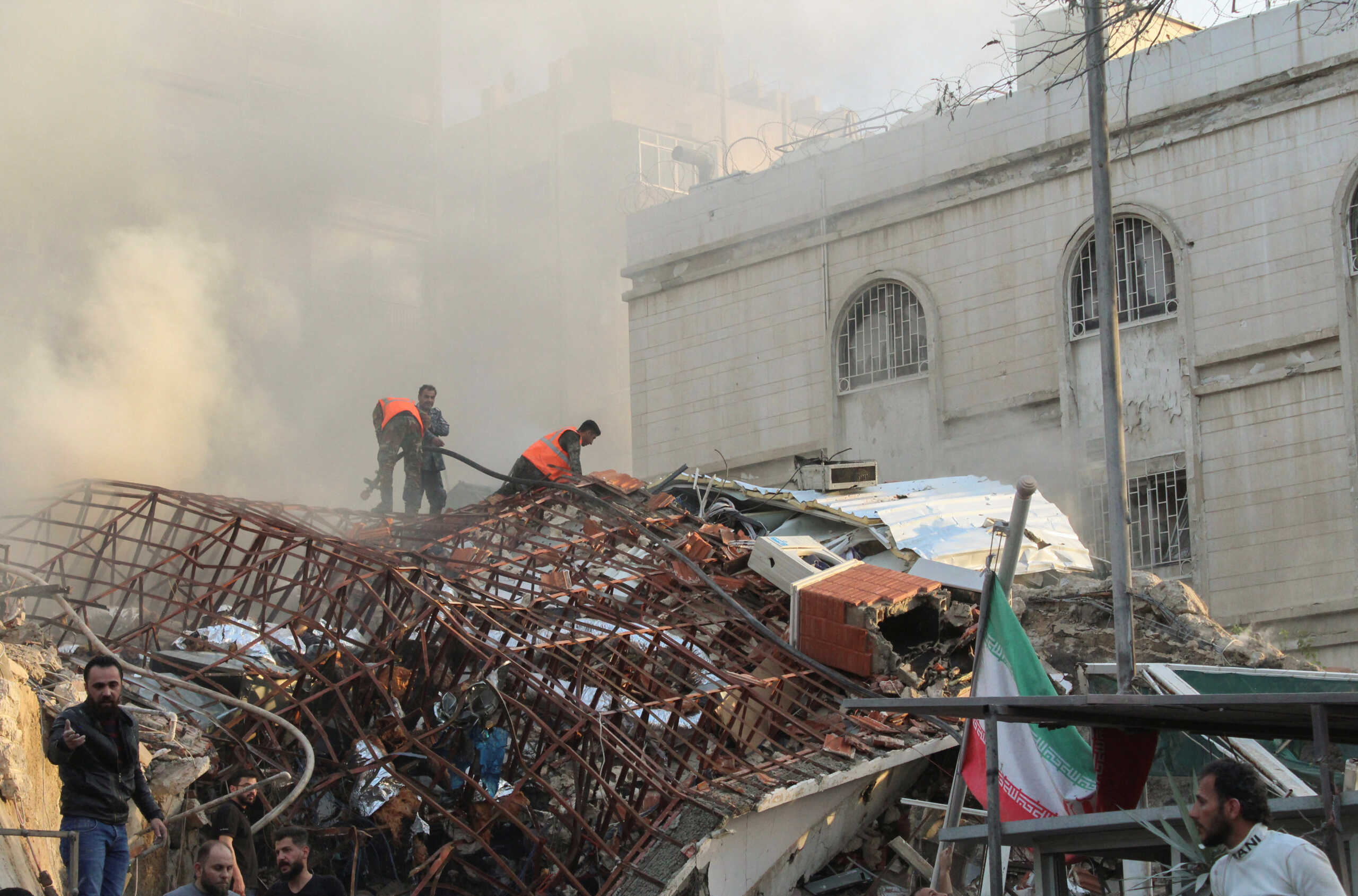 Members of the civil defence stand near a damaged site after what Syrian and Iranian media described as an Israeli air strike on Iran's consulate in the Syrian capital Damascus April 1, 2024. REUTERS