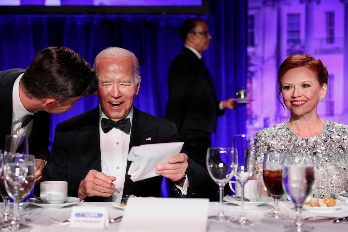 U.S. President Joe Biden reacts as host Colin Jost speaks to him as they, along with White House Correspondents' Association (WHCA) President and NBC News Senior White House Correspondent Kelly O'Donnell, attend the White House Correspondents' Association Dinner in Washington, U.S., April 27, 2024. REUTERS