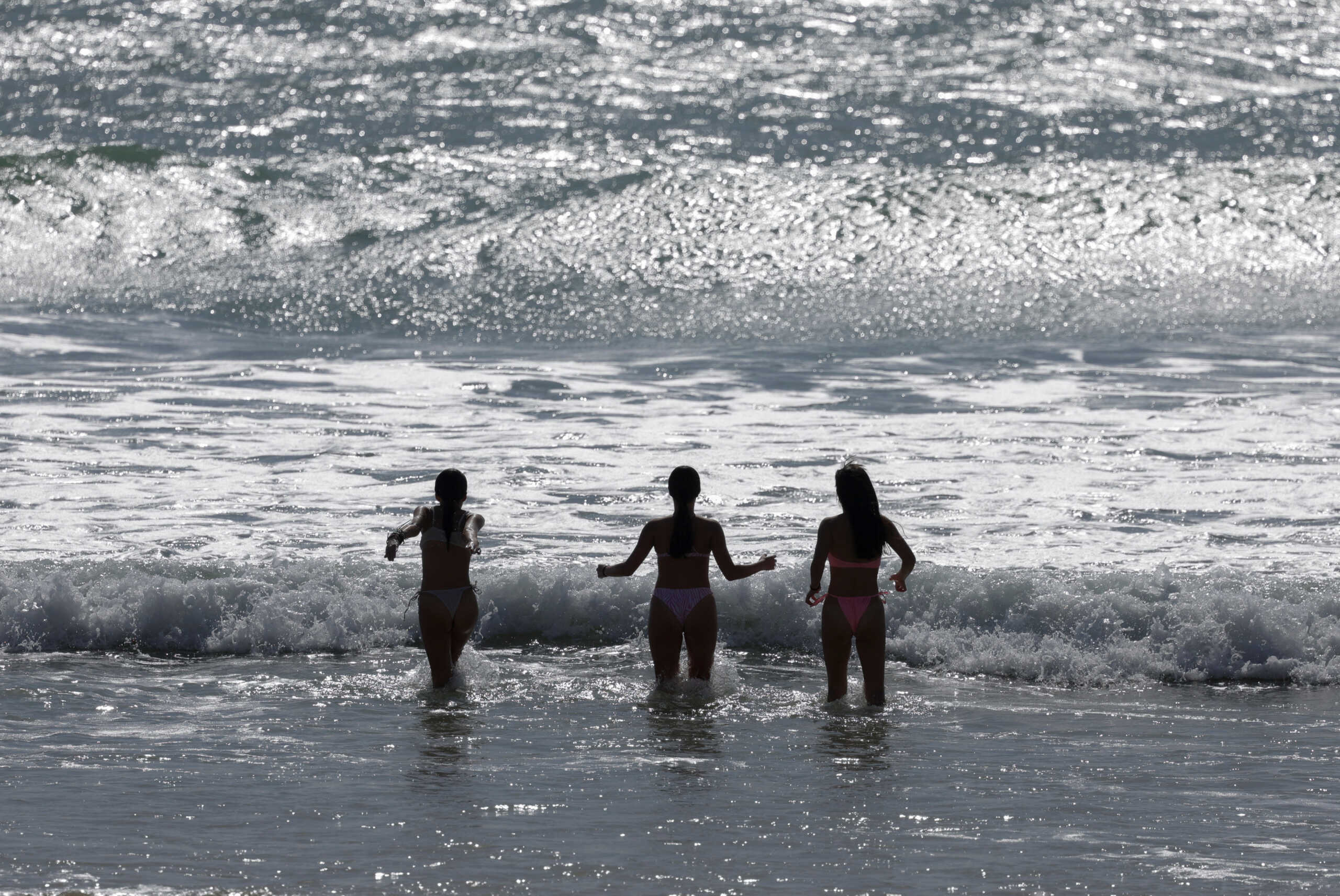 Girls cool off at the Atlantic Ocean on La Victoria beach during a sunny spring day with warm temperatures, in Cadiz, Spain April 13, 2024. REUTERS