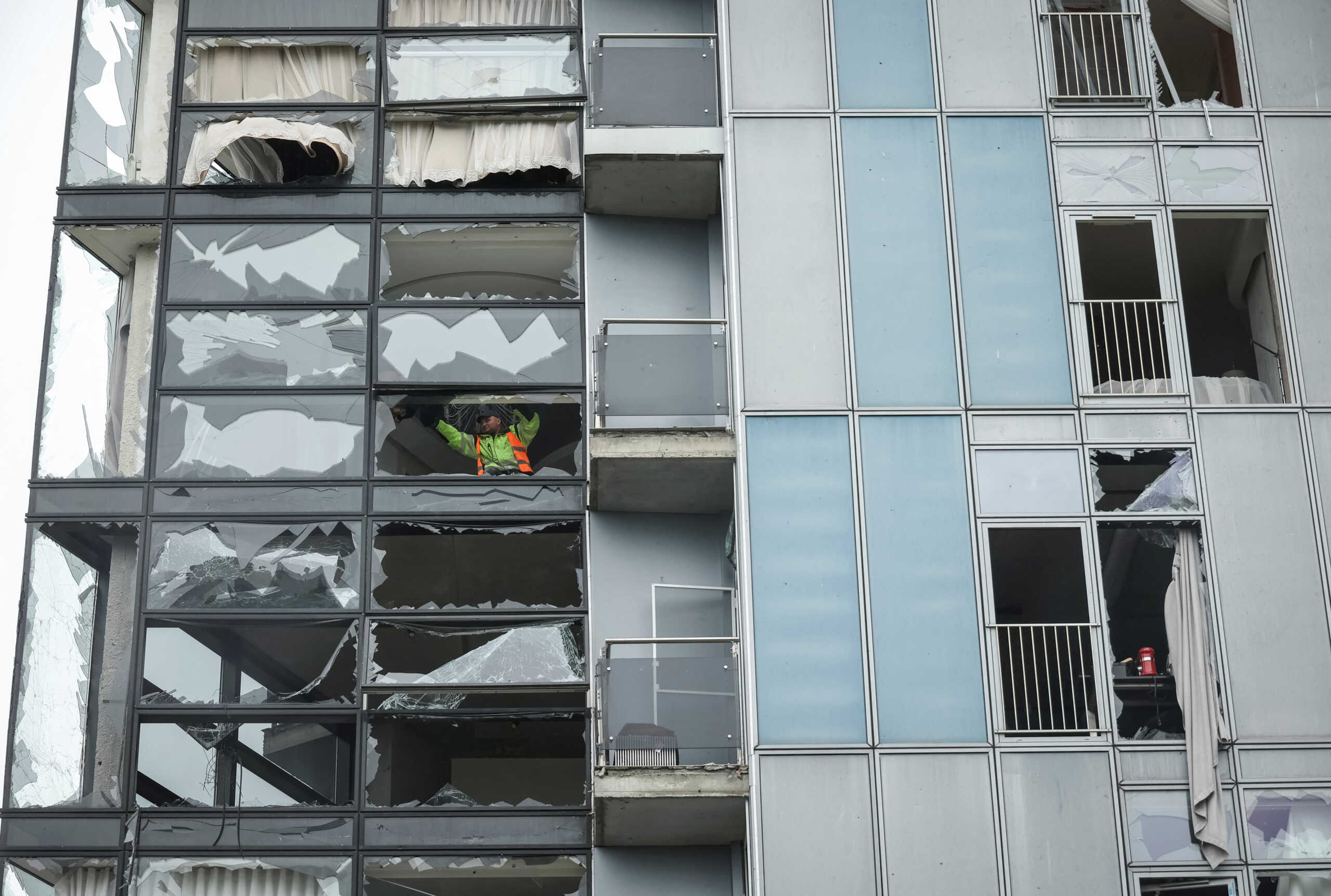 A worker removes shards of glass from broken windows of an apartment building damaged by a Russian missile strike in Kharkiv, amid Russia's attack on Ukraine April 24, 2024. REUTERS