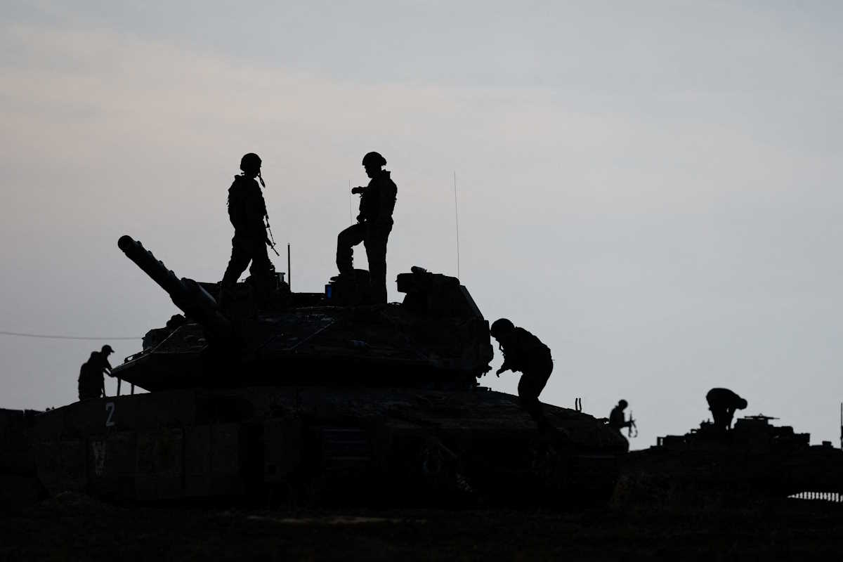 Israeli soldiers are silhouetted as they stand on a tank, near the Israel-Gaza border, amid the ongoing conflict between Israel and the Palestinian Islamist group Hamas, in Israel, May 2, 2024. REUTERS
