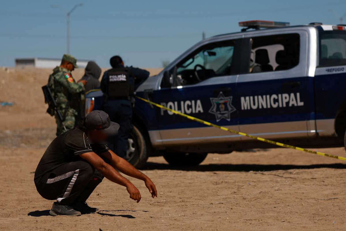 A migrant seeking asylum in the United States observes the scene where a migrant was found dead, according to local media, showing bruises in different parts of the body, on the banks of the Rio Bravo, the border between Mexico and the United States, in Ciudad Juarez, Mexico, May 17, 2024. REUTERS