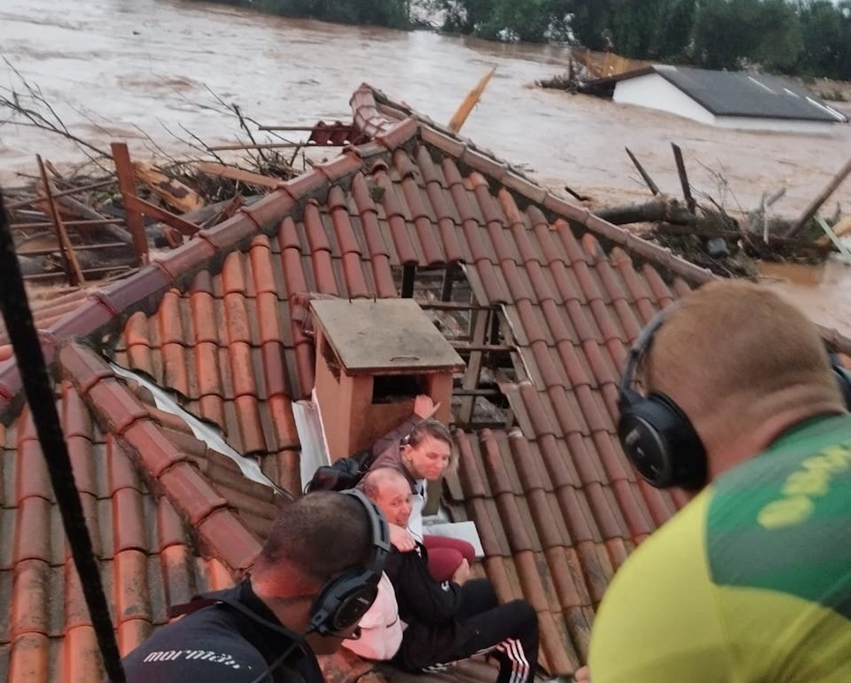 People trapped on the roof of a house by heavy rains are rescued in Cruzeiro do sul, Rio Grande do Sul, Brazil, May 2, 2024.    @brigadamilitar_ via X