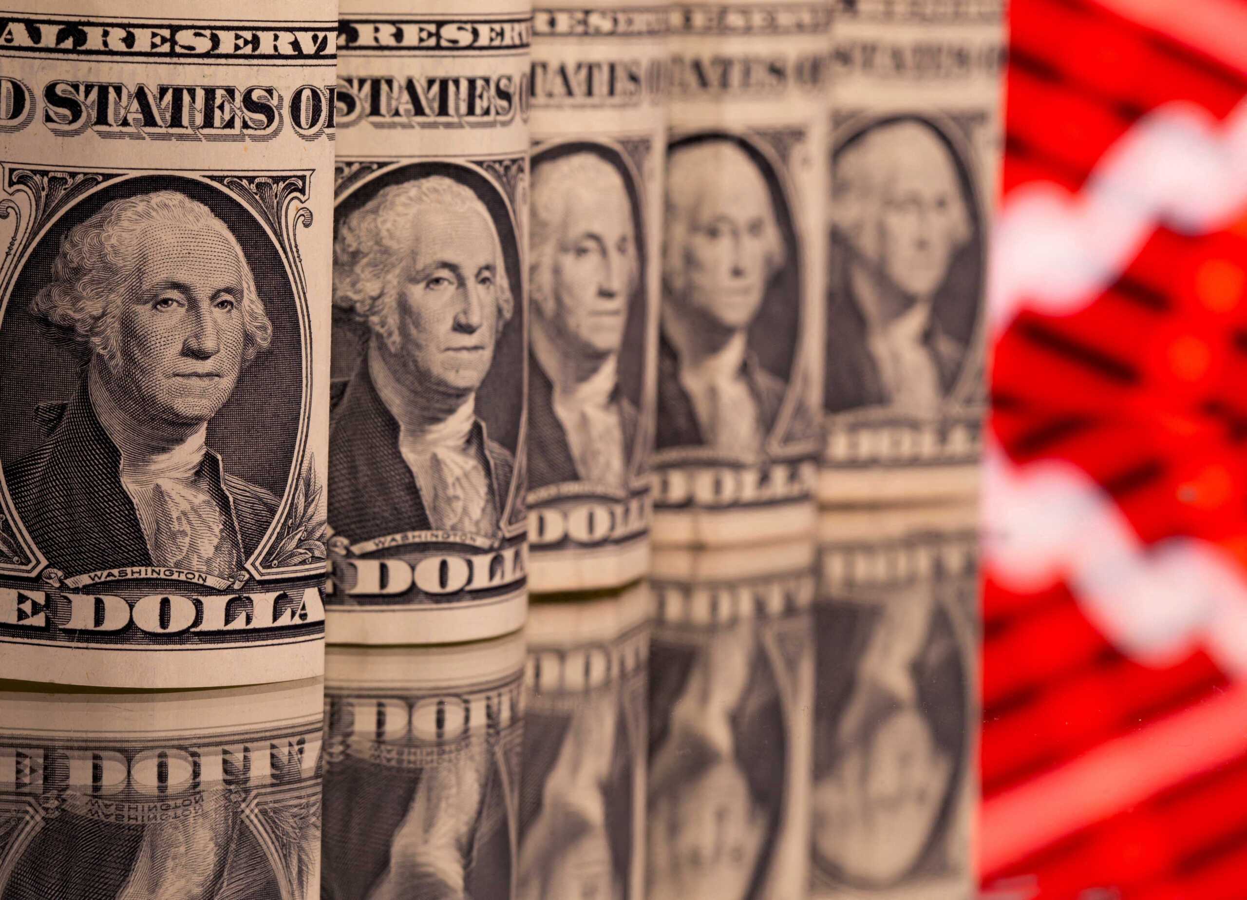 FILE PHOTO: U.S. one dollar banknotes are seen in front of displayed stock graph in this illustration taken February 8, 2021. REUTERS