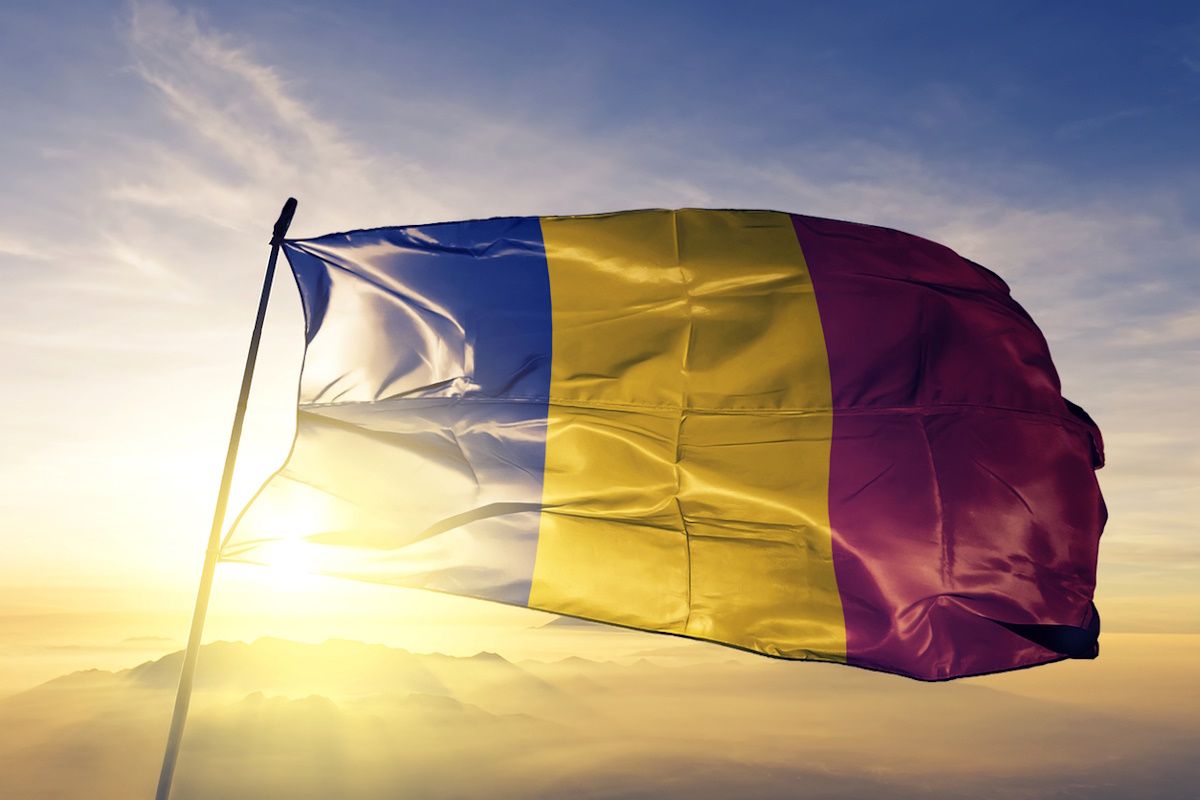 Romania Romanian flag on flagpole textile cloth fabric waving on the top sunrise mist fog