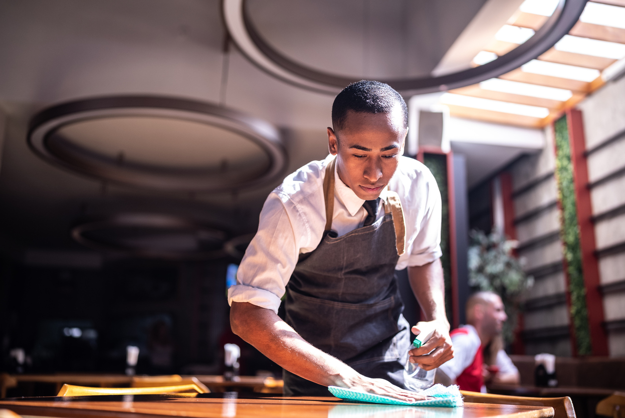 Waiter cleaning a dining table at a restaurant