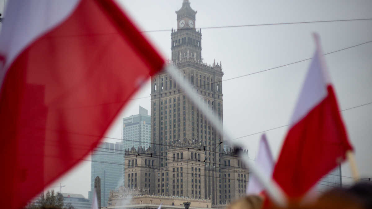 Warsaw, Poland - November 11, 2018: Polish flags in the foreground, the back the Palace of Culture and Science is seen along with some of the Warsaw skyline during Independence Day celebrations.