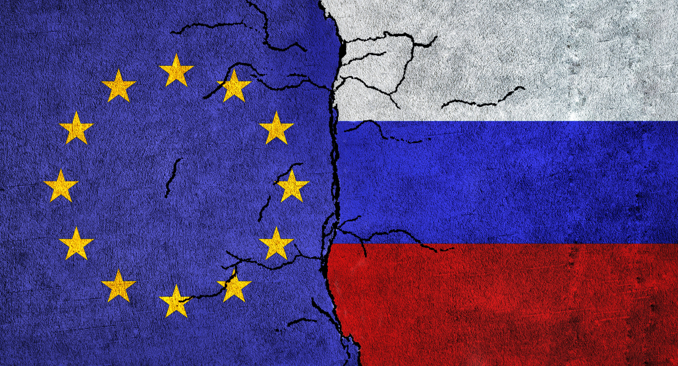 Russia and European Union painted flags on a wall with grunge texture. Russia vs EU