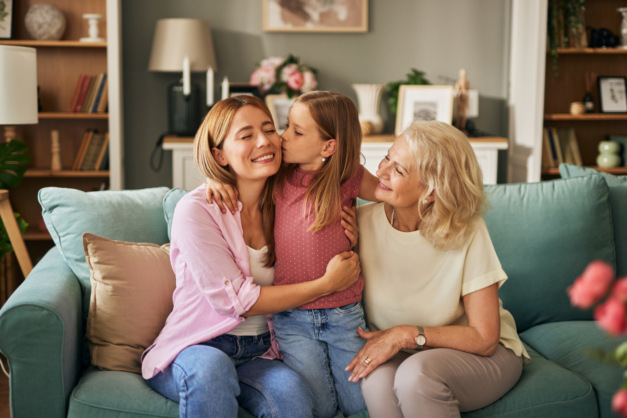 Three female generation portrait. Little girl kissing her mother