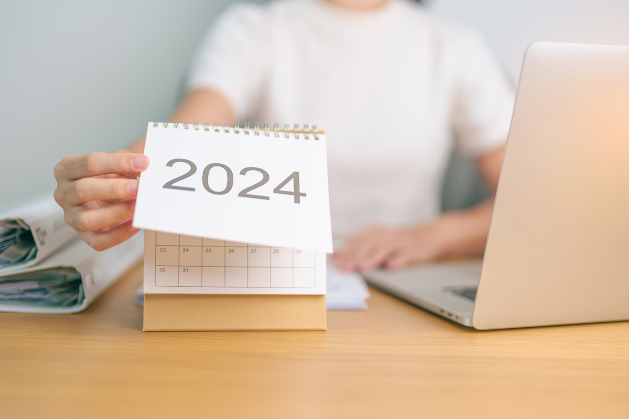 2024 Year Calendar on table with business woman using laptop computer. countdown, Happy New Year, Resolution, Goals, Plan,  Action, Mission and financial Concept