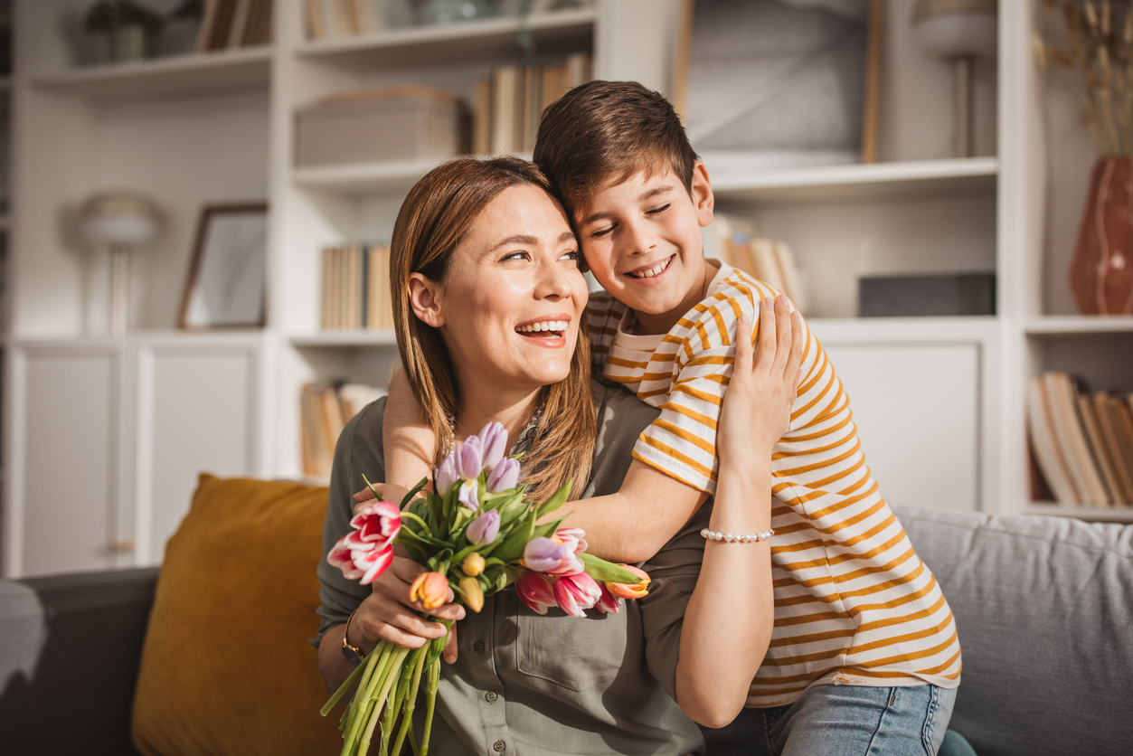 Happy son giving bouquet of tulips to his mother for mother's day.