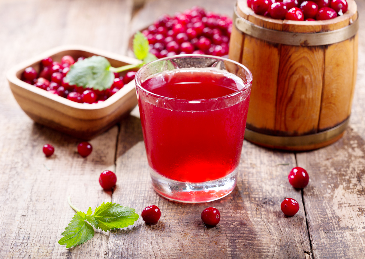 glass of cranberry juice with fresh berries on wooden table