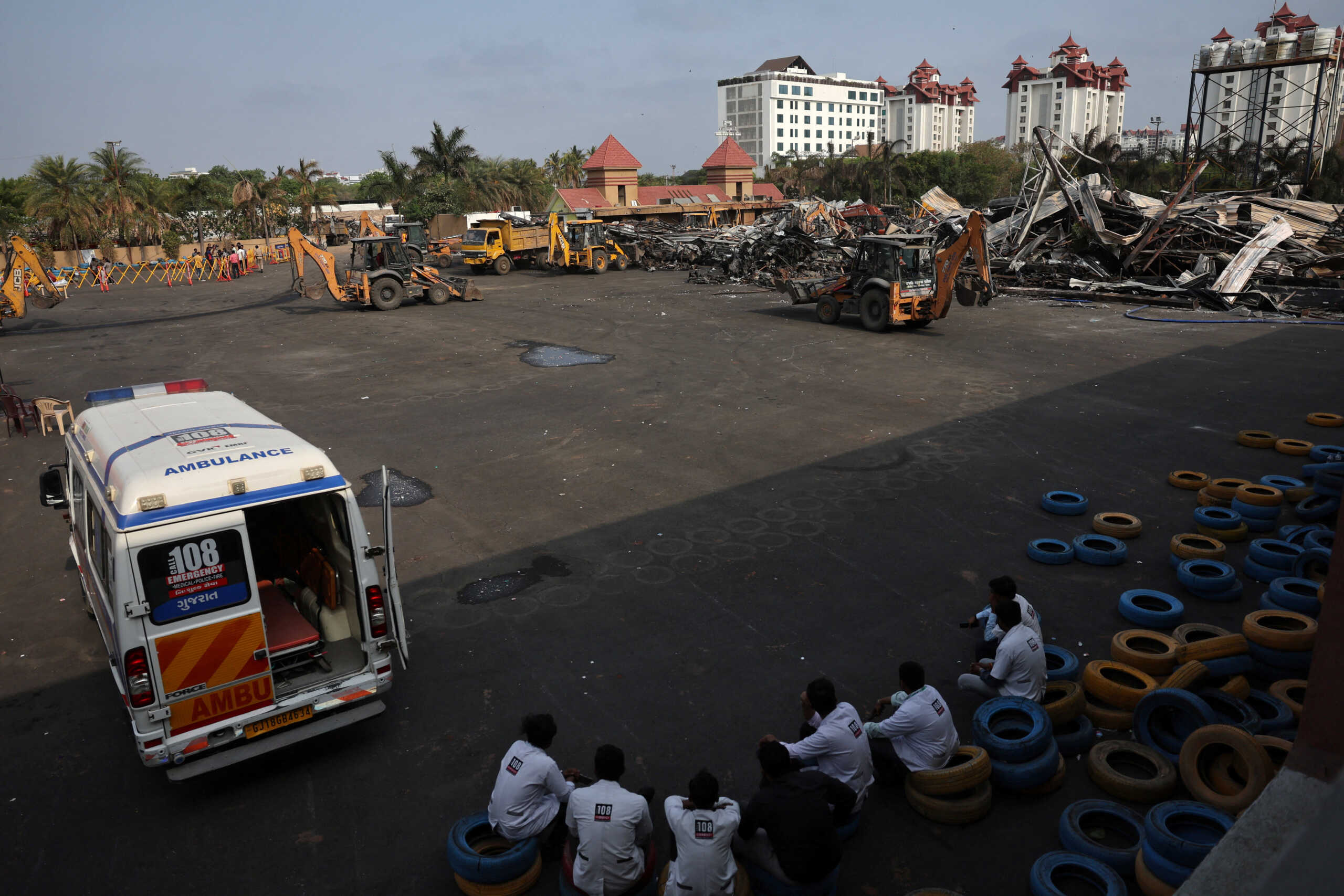 Paramedics rest in the shade as the search for victims continue amidst the debris following a fire in a gaming zone in Rajkot, in the western state of Gujarat, India, May 26, 2024. REUTERS