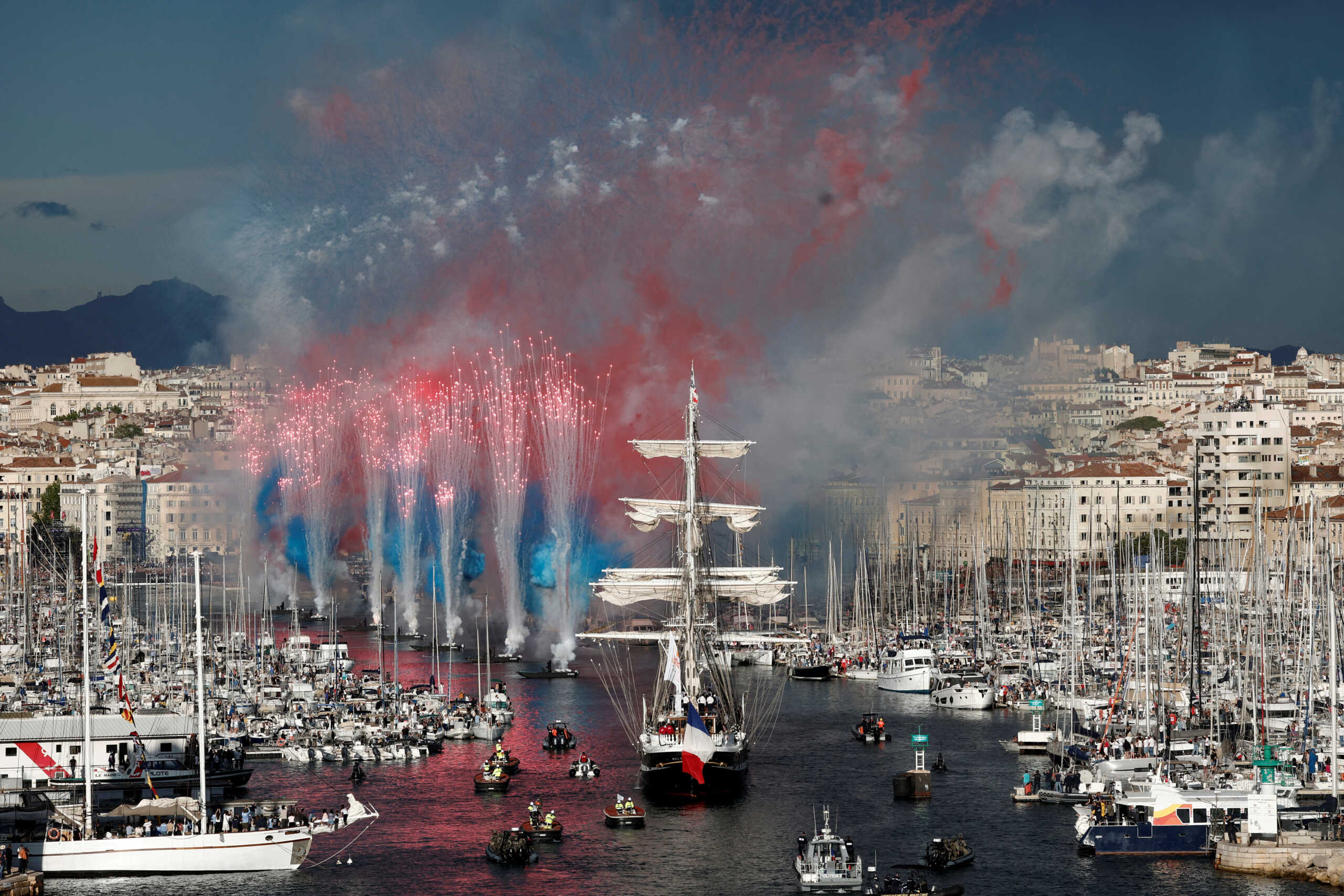 Paris Olympics 2024 - Arrival of the Olympic Flame in Marseille - Marseille, France - May 8, 2024  General view of flares as the "Belem", a three-masted sailing ship that carries the Olympic Flame arrives at the Old Port ahead of the Paris Olympics 2024 REUTERS
