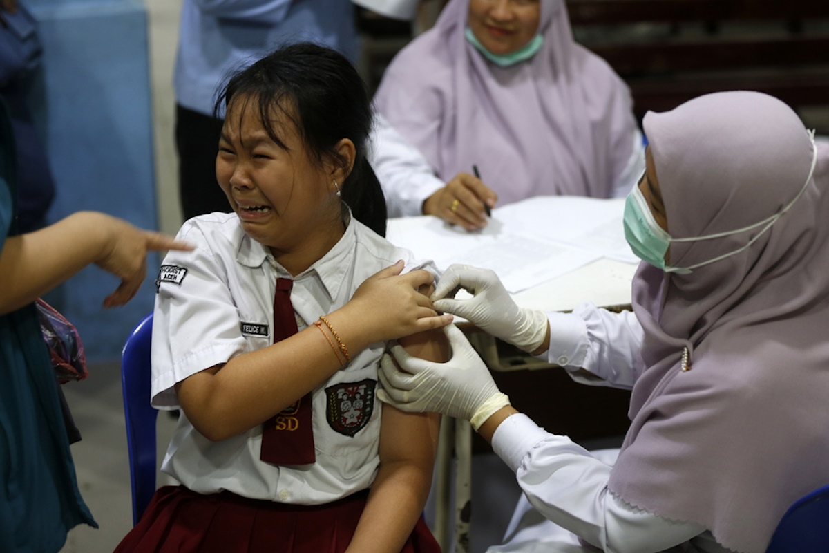epa10824803 A school child reacts as she receives an injection during a vaccination program of the Measles-Rubella (MR) and Human Papillomavirus (HPV) in Banda Aceh, Indonesia, 28 August 2023. The Human Papillomavirus (HPV) vaccination program is for school children at the fifth grade of Elementary school as a preventive action against cancer in the genital area and reproductive organs such as cervical cancer and penile cancer.  EPA
