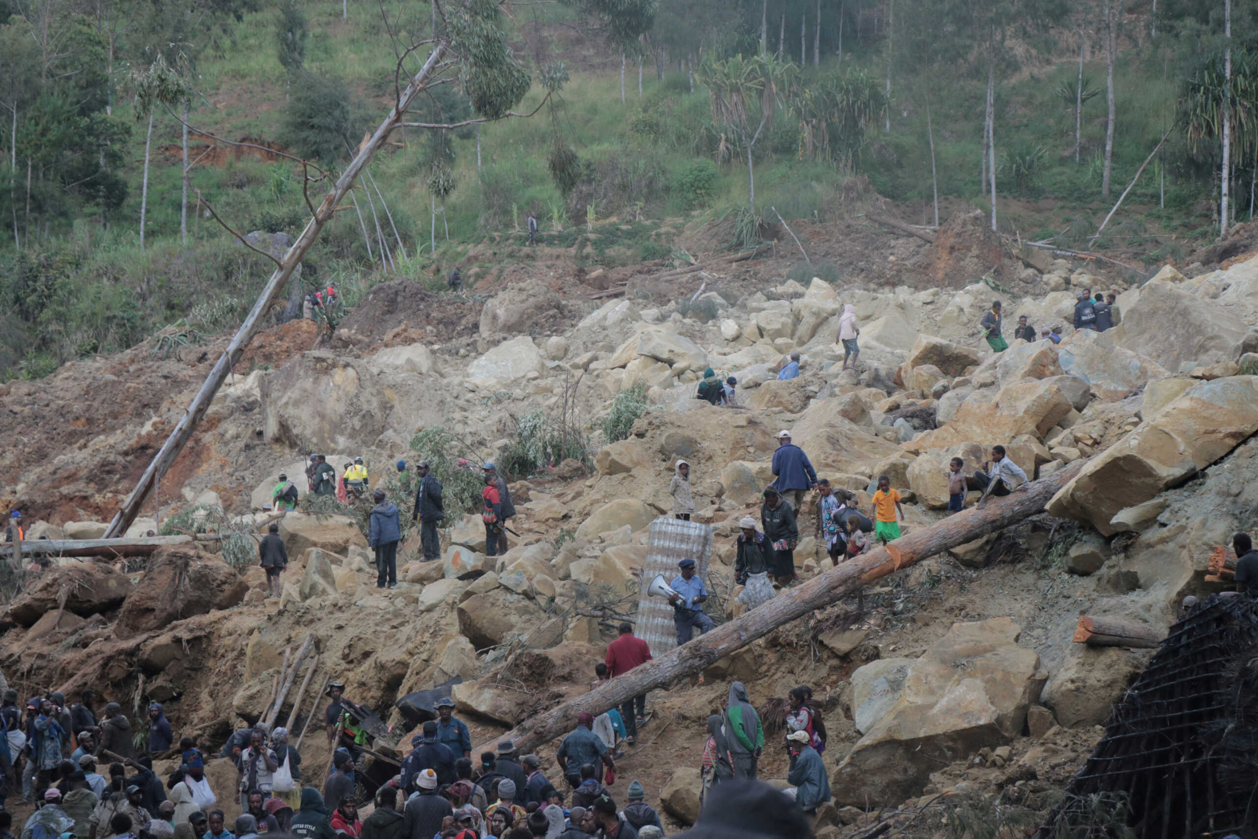 Relief workers and people gather at a site damaged in the aftermath of a landslide in Enga Province, Papua New Guinea, May 26, 2024, in this handout image obtained by Reuters.  New Porgera Limited