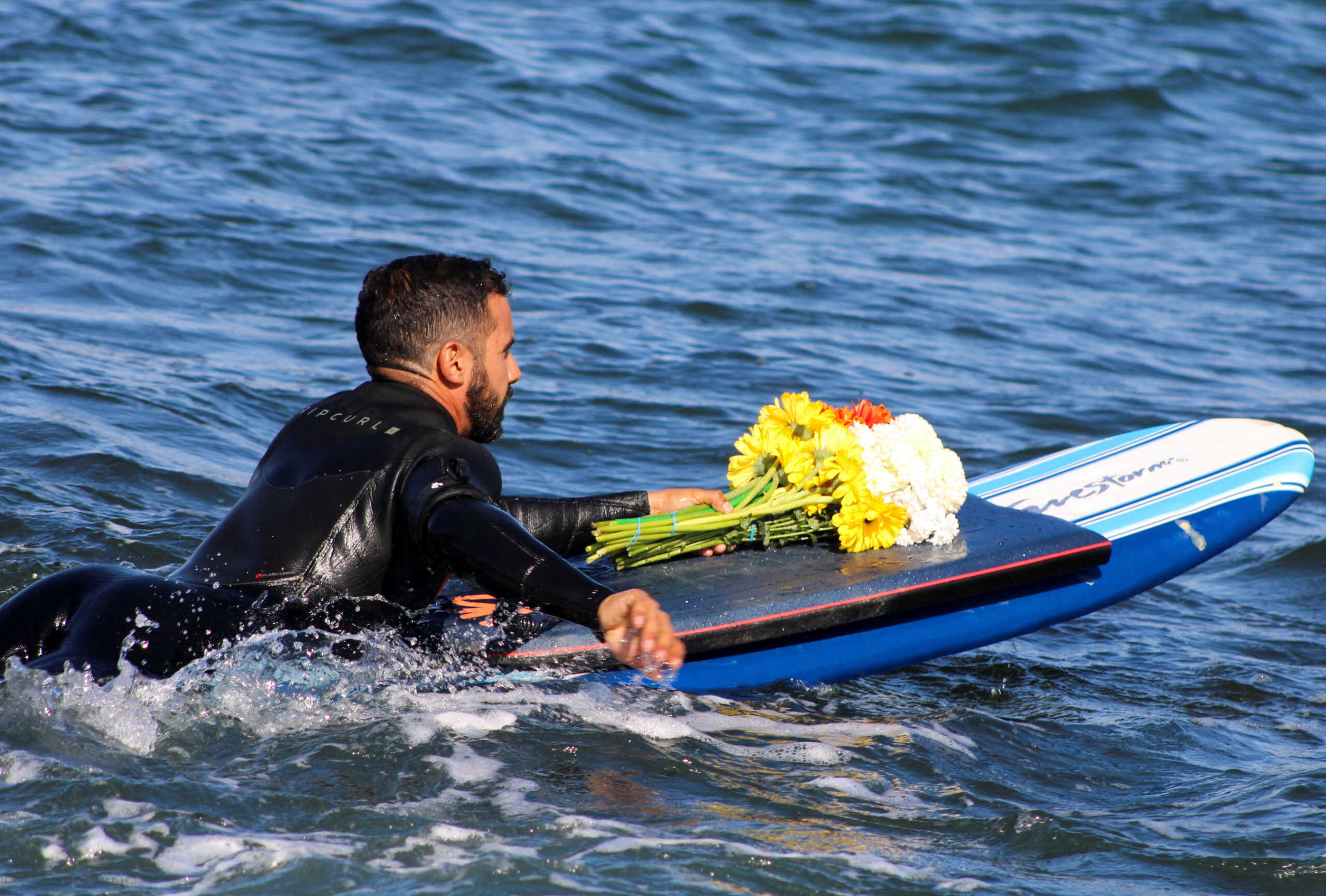 A local surfer participates in a paddle-out, a tribute to the life of people who passed away, as Mexican authorities confirmed U.S. and Australian tourists who went missing in northern Mexico last week are dead after their bodies were identified by their parents, in Ensenada, Mexico May 5, 2024. REUTERS