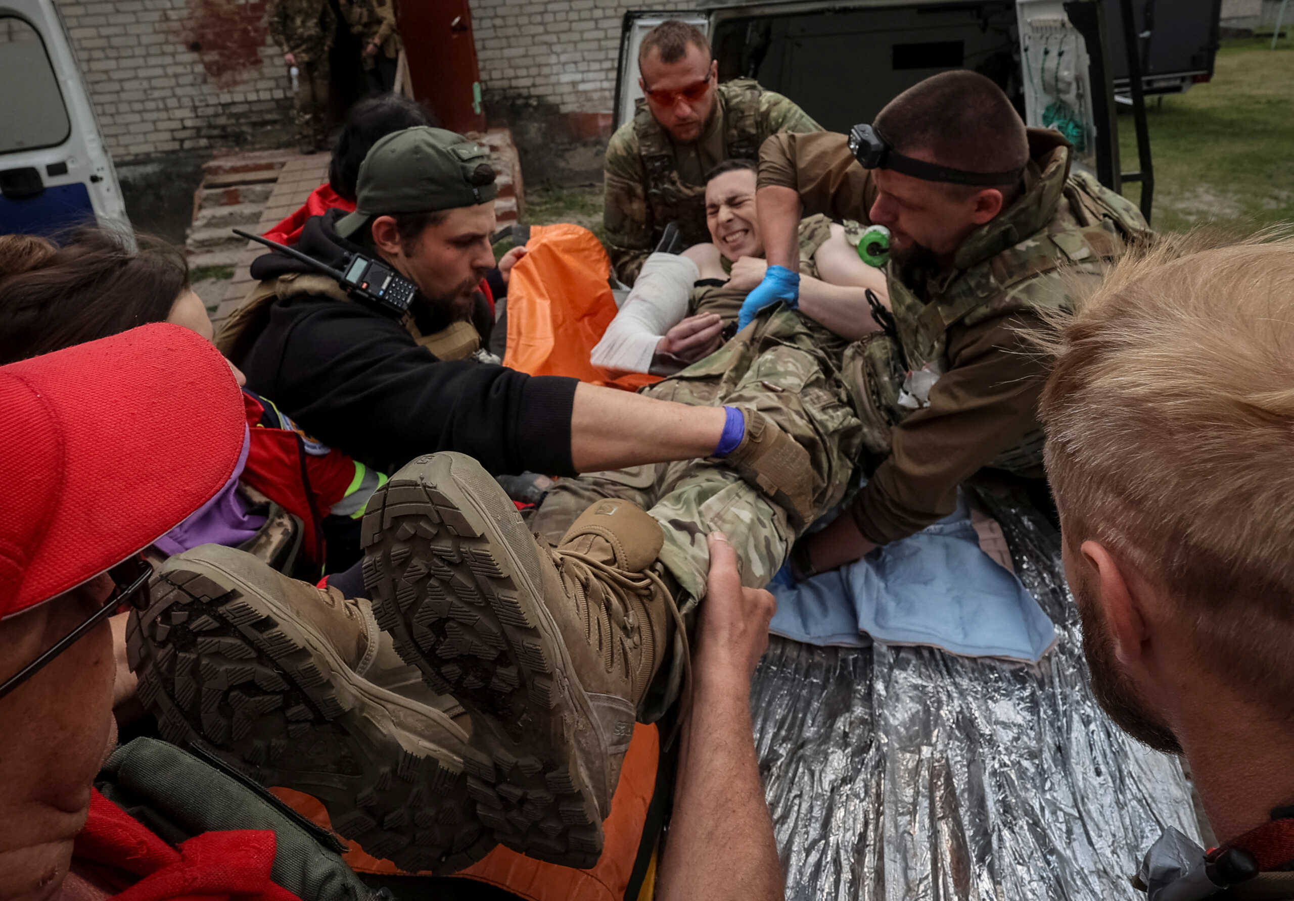 Medical workers and servicemen treat a wounded Ukrainian service member, amid Russia's attack on Ukraine, near the town of Vovchansk in Kharkiv region, Ukraine May 12, 2024. REUTERS