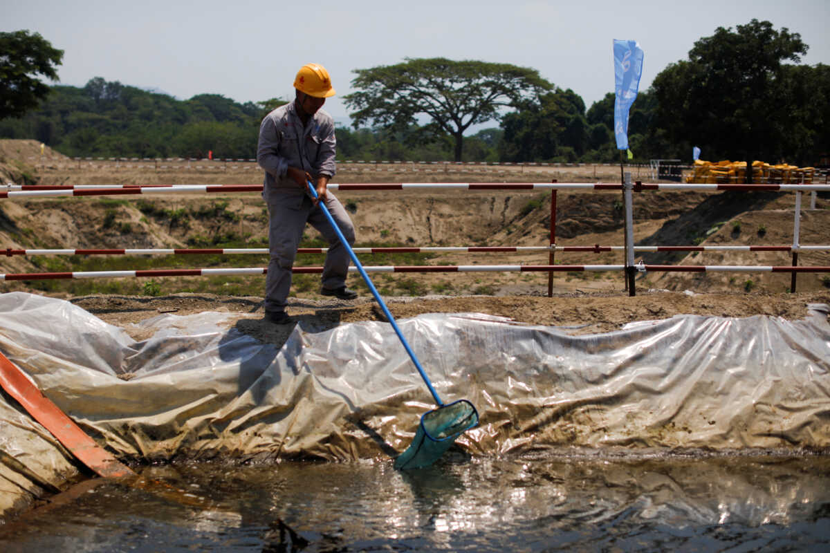 A Chinese worker cleans a pond at the construction site of a new water purification plant, financed by China, in Santiago Texacuangos, El Salvador April 26, 2024. REUTERS