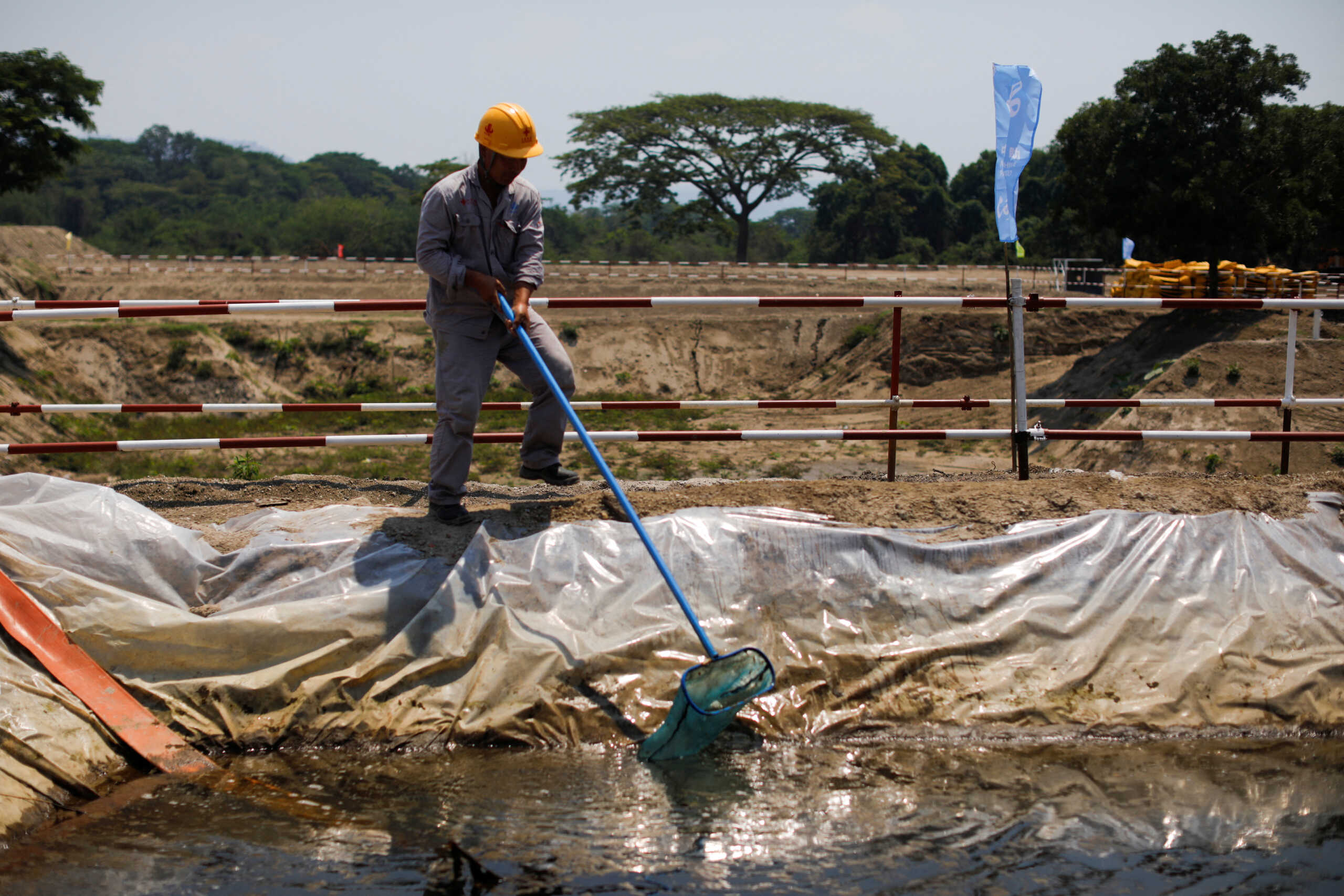 A Chinese worker cleans a pond at the construction site of a new water purification plant, financed by China, in Santiago Texacuangos, El Salvador April 26, 2024. REUTERS