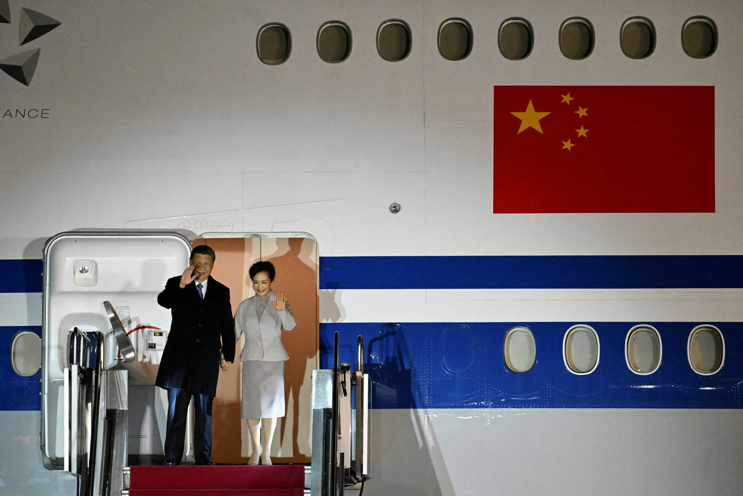 Chinese President Xi Jinping and his wife Peng Liyuan wave as they arrive at the Ferenc Liszt International Airport in Budapest, Hungary, May 8, 2024.   SZILARD KOSZTICSAK