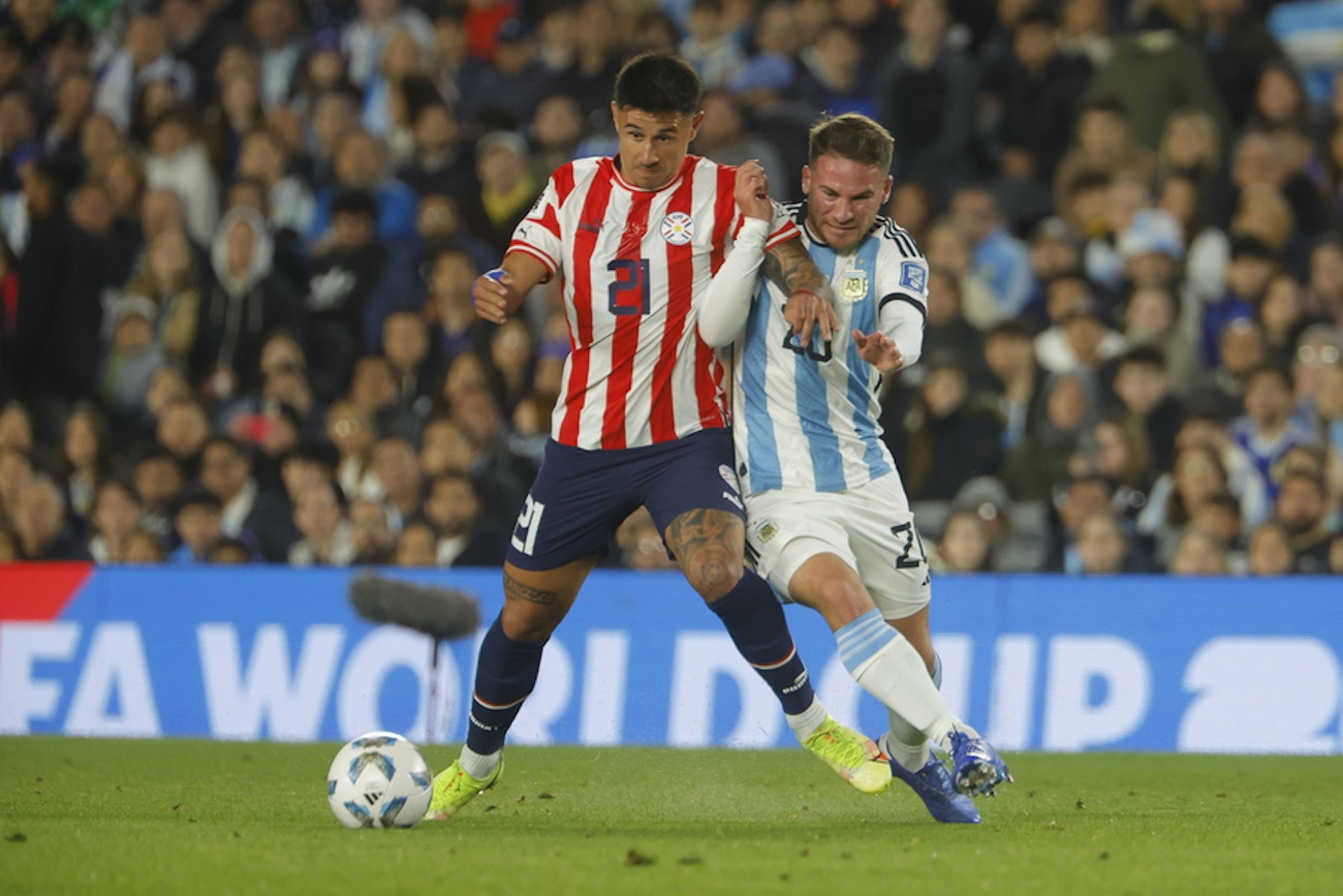 epa10915883 Alexis Mac Allister (R) of Argentina vies for the ball with Adam Bareiro of Paraguay during a CONMEBOL FIFA World Cup 2026 qualifier soccer match between Argentina and Paraguay at Mas Monumental stadium in Buenos Aires, Argentina, 12 October 2023.  EPA