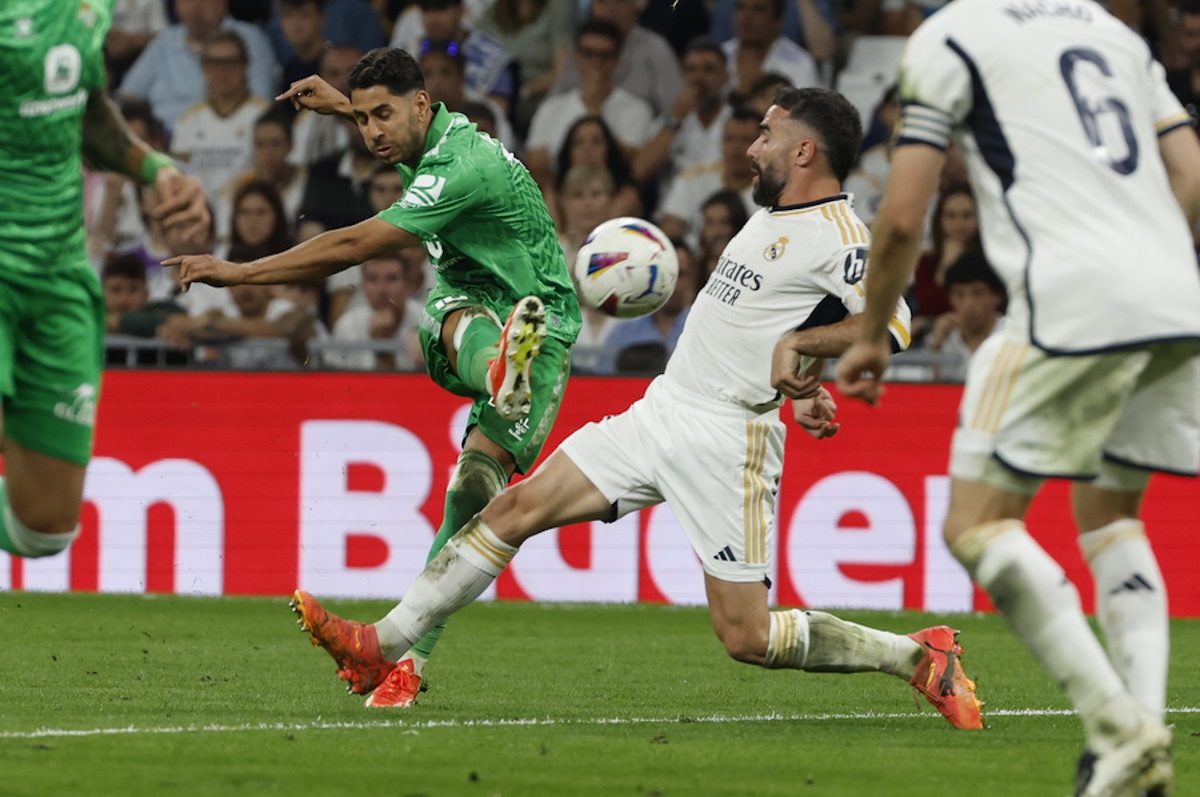 epa11370082 Real Madrid's defender Dani Carvajal (R) in action against Real Betis' striker Ayoze Perez (C) during the LaLiga soccer match between Real Madrid and Real Betis at Santiago Bernabeu stadium in Madrid, Spain, 25 May 2024.  EPA