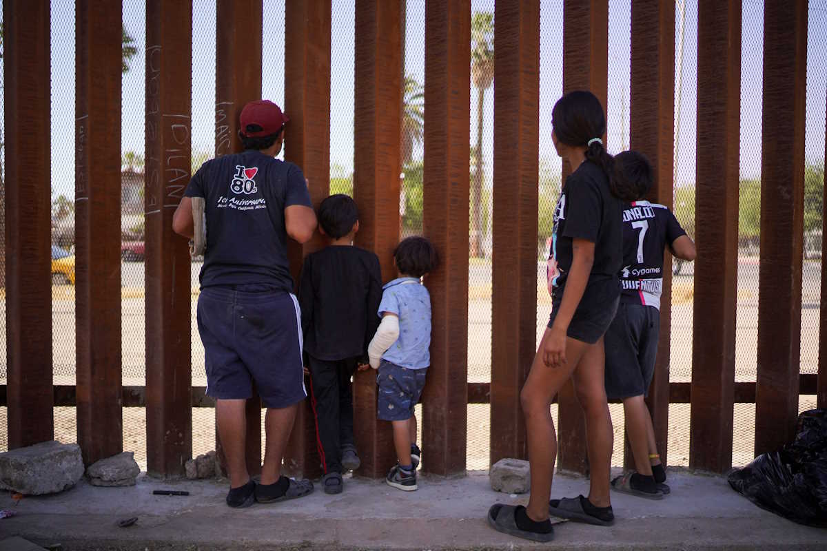 A Colombian family waits for a CBP One appointment to reach the United States as they rest next to the border wall during a heat wave in Mexicali, Mexico June 14, 2024 REUTERS
