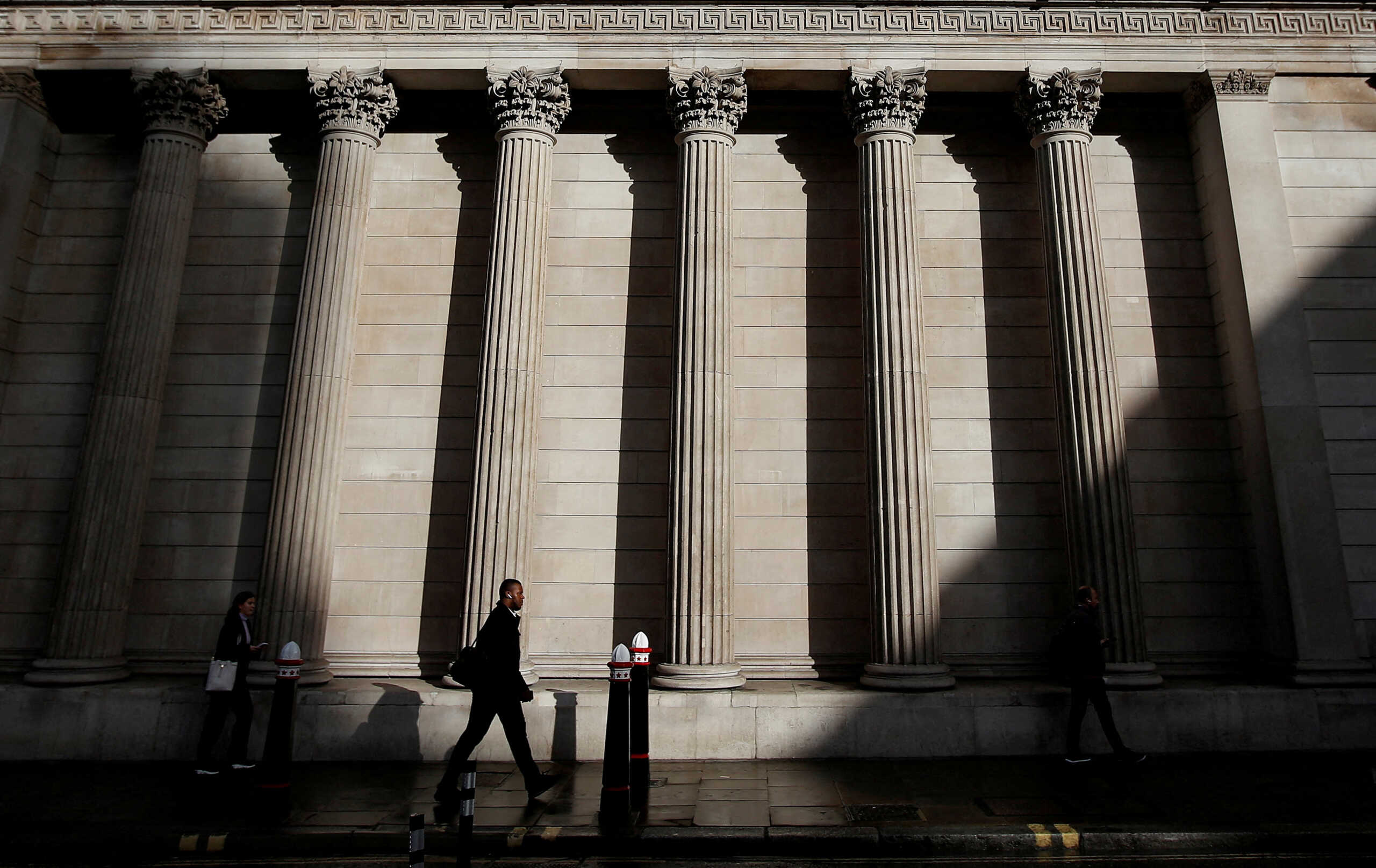 FILE PHOTO: A commuter walks past the Bank of England, in London, Britain, September 26, 2022. REUTERS