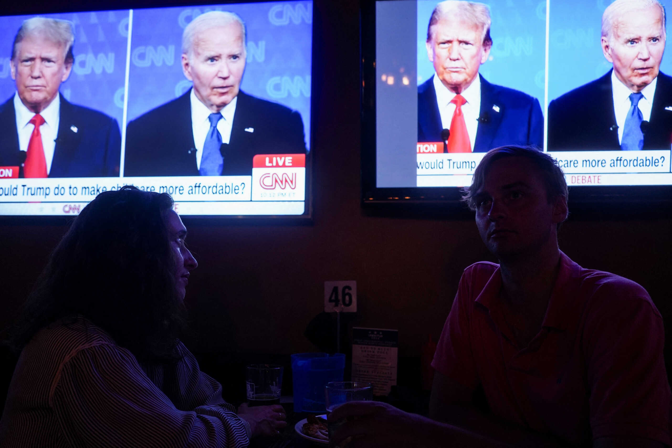 Republican presidential candidate, former U.S. President Donald Trump and Democrat presidential candidate, U.S. President Joe Biden are seen on television as people attend a watch party for the first U.S. presidential debate hosted by CNN in Atlanta, at Union Pub on Capitol Hill in Washington, U.S., June 27, 2024. REUTERS