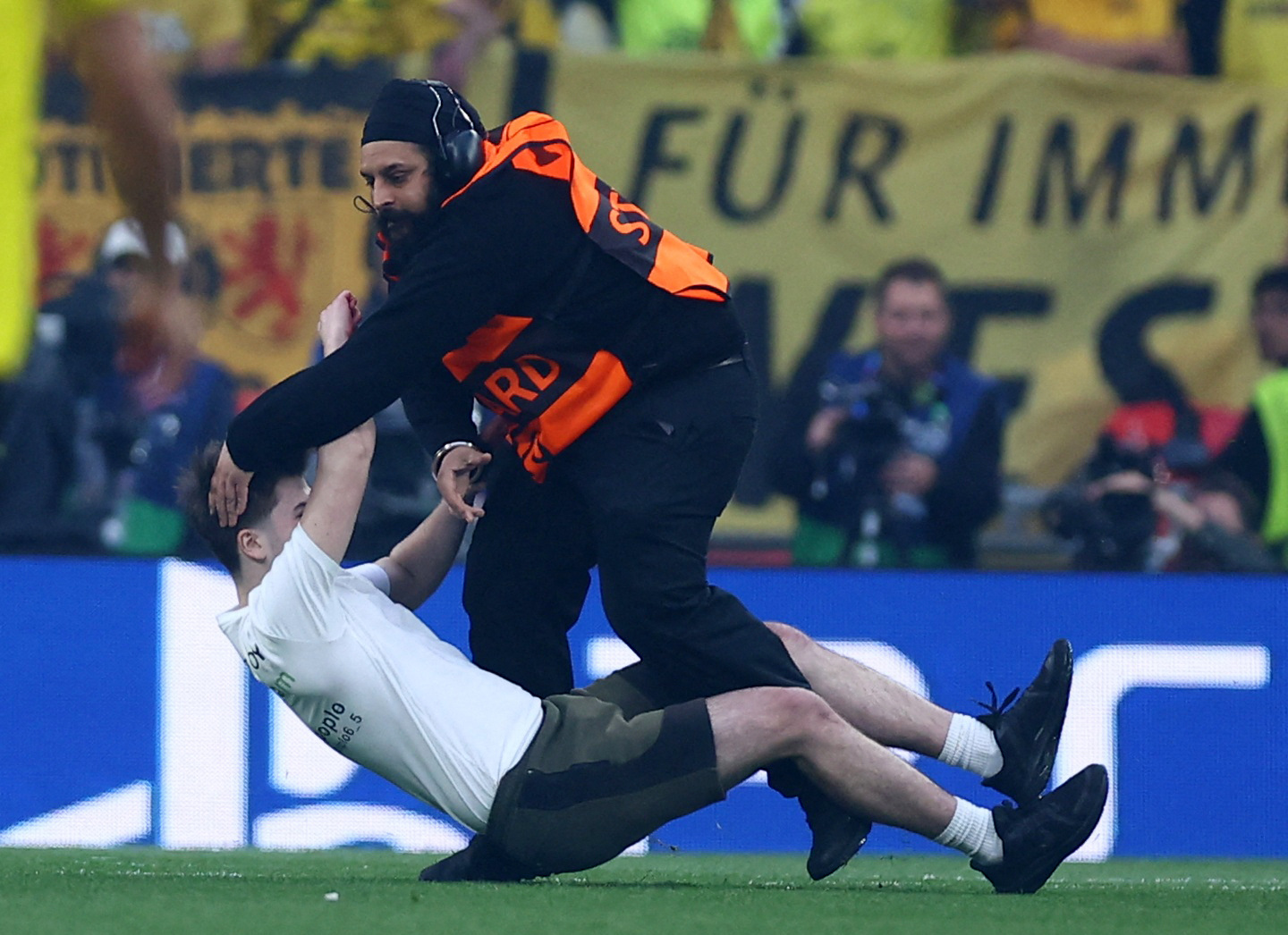 Soccer Football - Champions League - Final - Borussia Dortmund v Real Madrid - Wembley Stadium, London, Britain - June 1, 2024 A pitch invader is tackled by a steward at the start of the match REUTERS