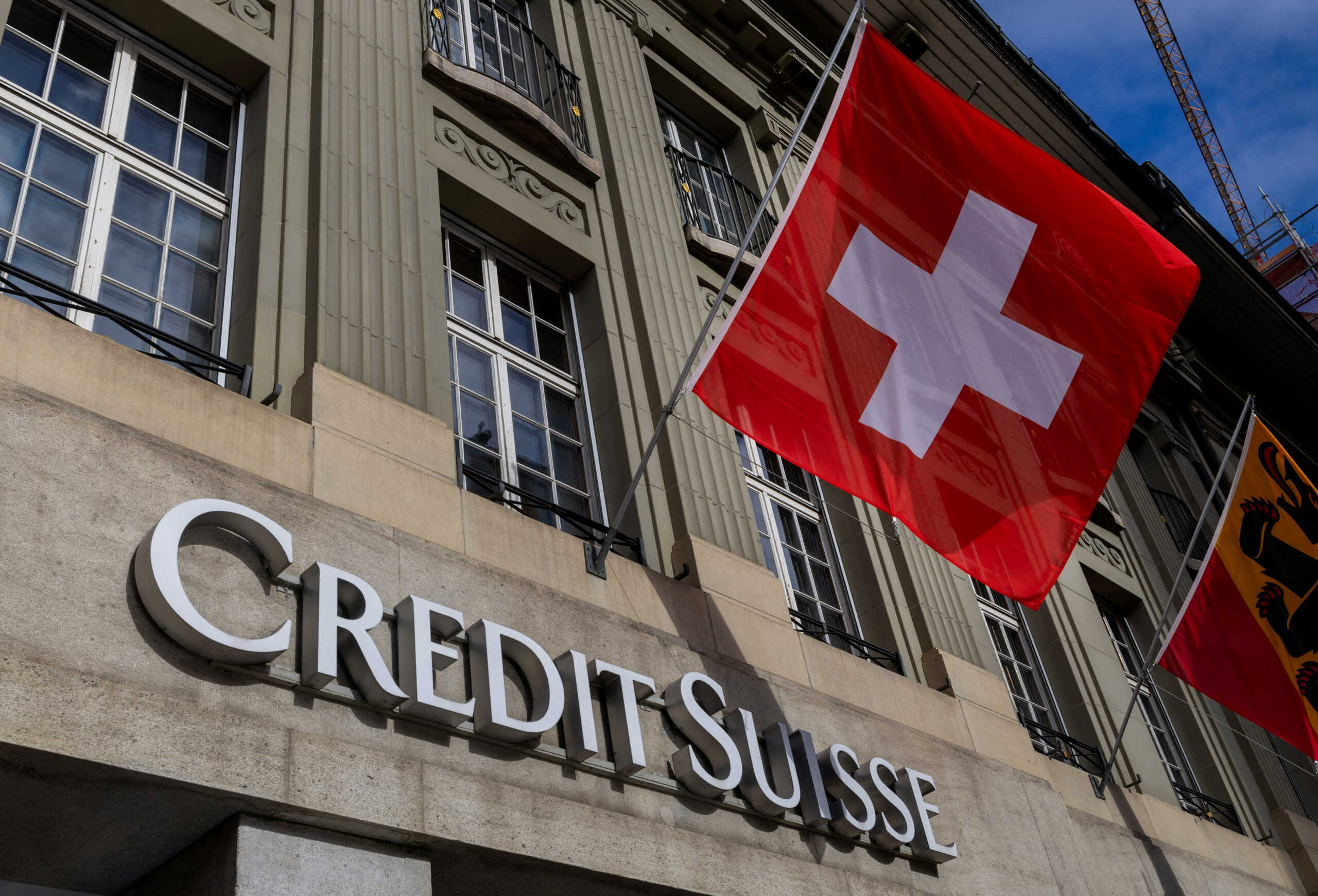 FILE PHOTO: A Swiss flag is pictured above a logo of Swiss bank Credit Suisse in Bern, Switzerland, November 15, 2023.  REUTERS