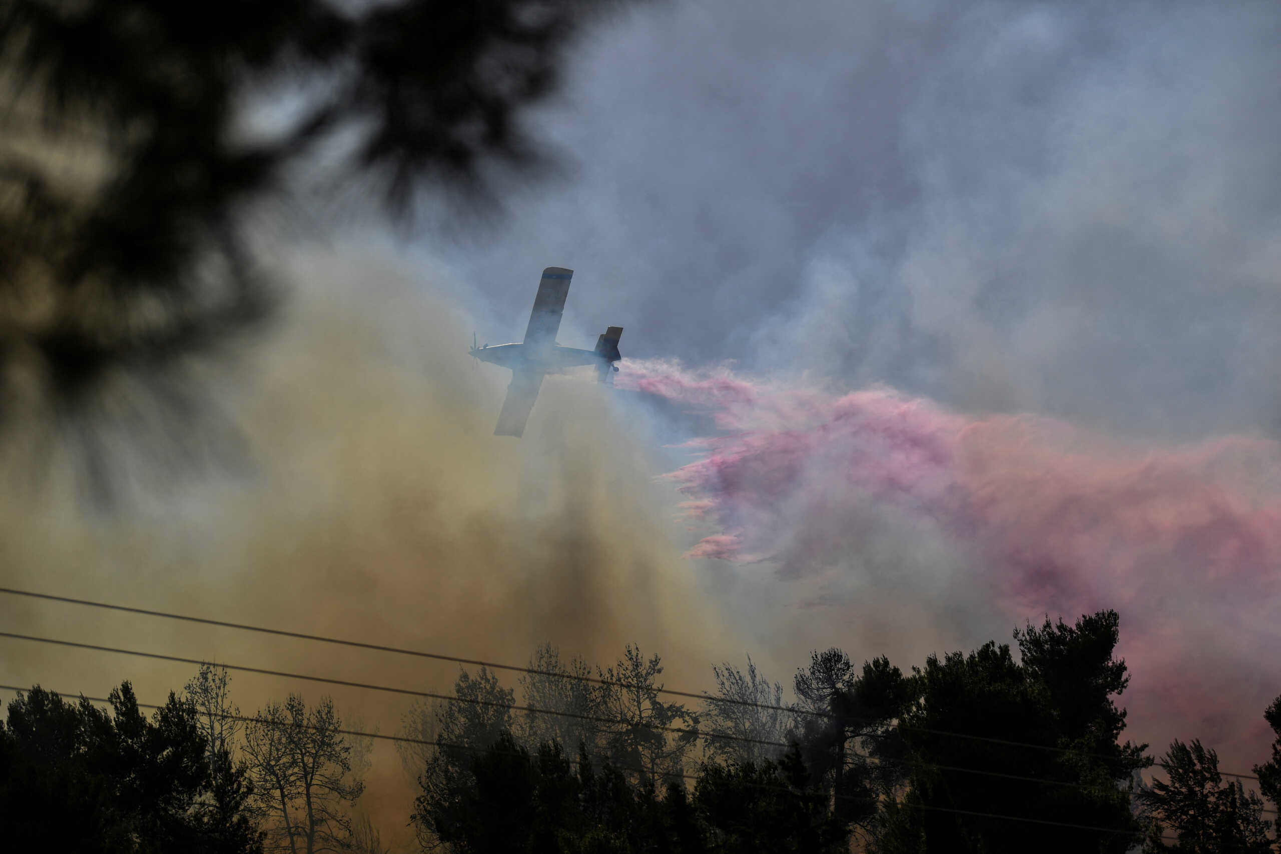 A firefighting plane disperses fire retardant as it assists in extinguishing fire following over border rockets launching to Israel from Lebanon, amid ongoing cross-border hostilities between Hezbollah and Israeli forces, in northern Israel June 13, 2024. REUTERS