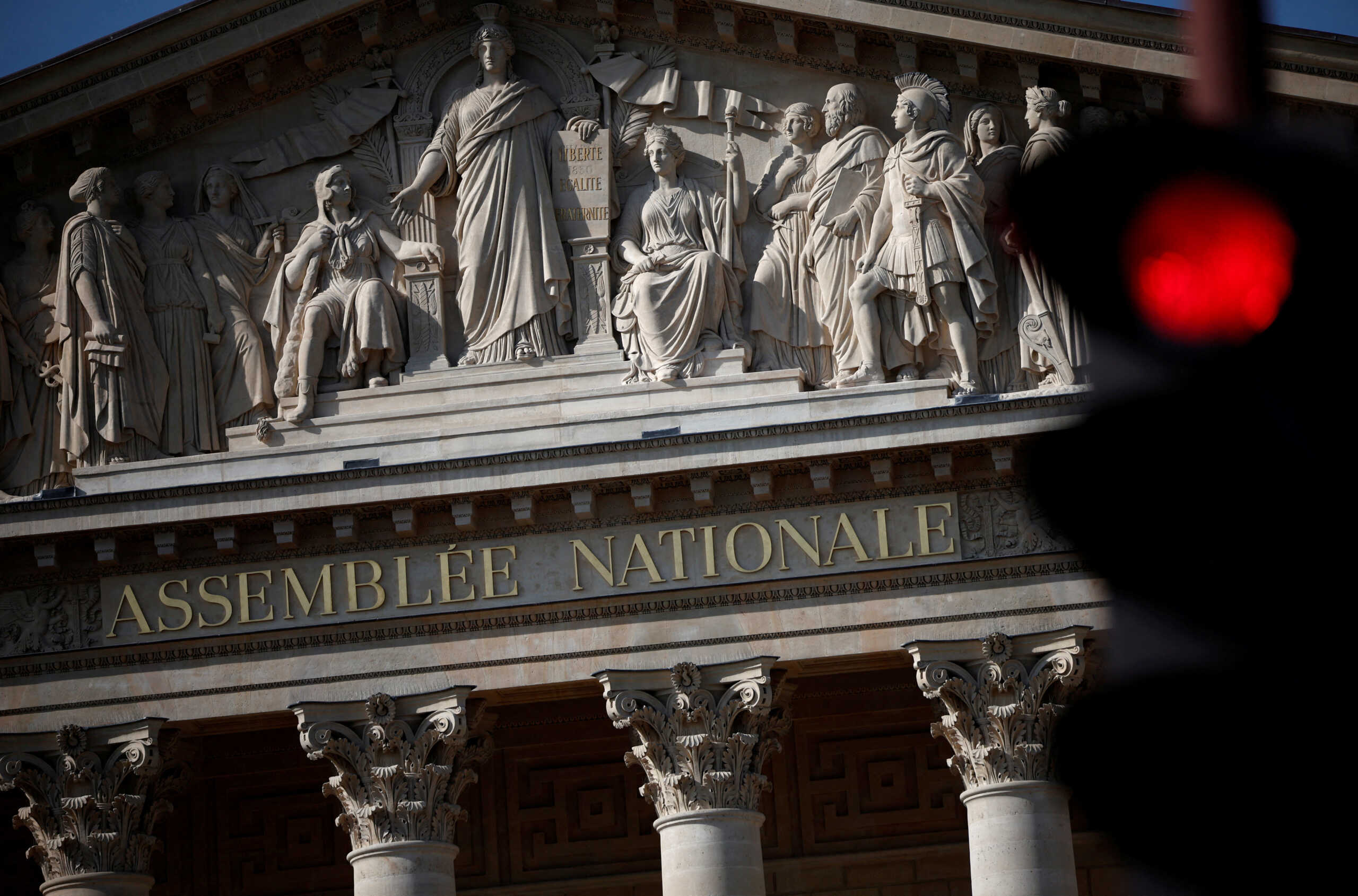 FILE PHOTO: A traffic light shines red near the National Assembly in Paris, ahead of early legislative elections in France, June 13, 2024. REUTERS