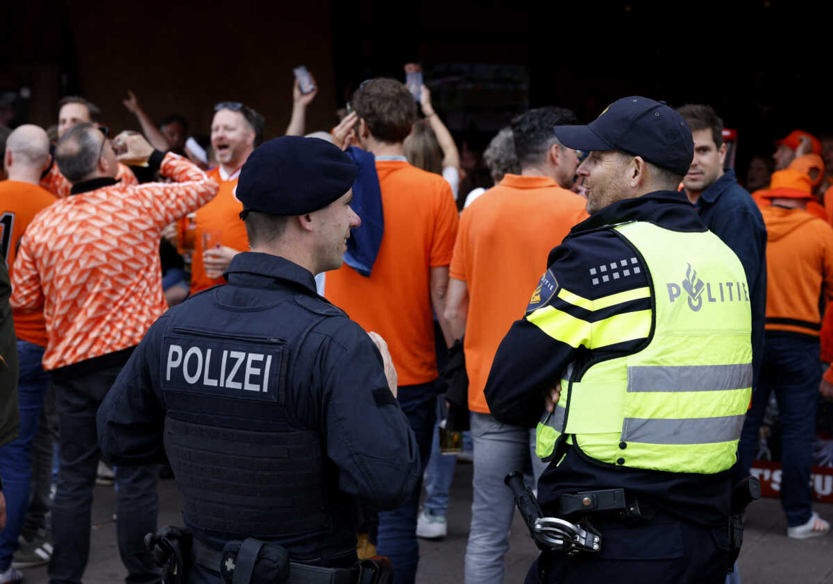 Soccer Football - Euro 2024 - Fans before Poland v Netherlands - Hamburg, Germany - June 15, 2024 Netherlands fans gather before Poland v Netherlands as police officers look on REUTERS