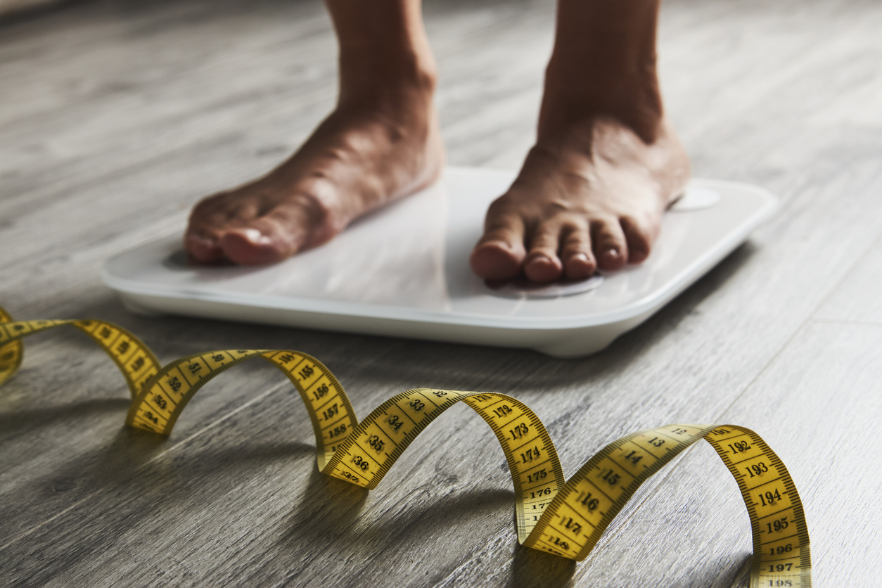 Woman on scales and measuring tape, close-up. Diet, healthy lifestyle, loss weight, slim concept.