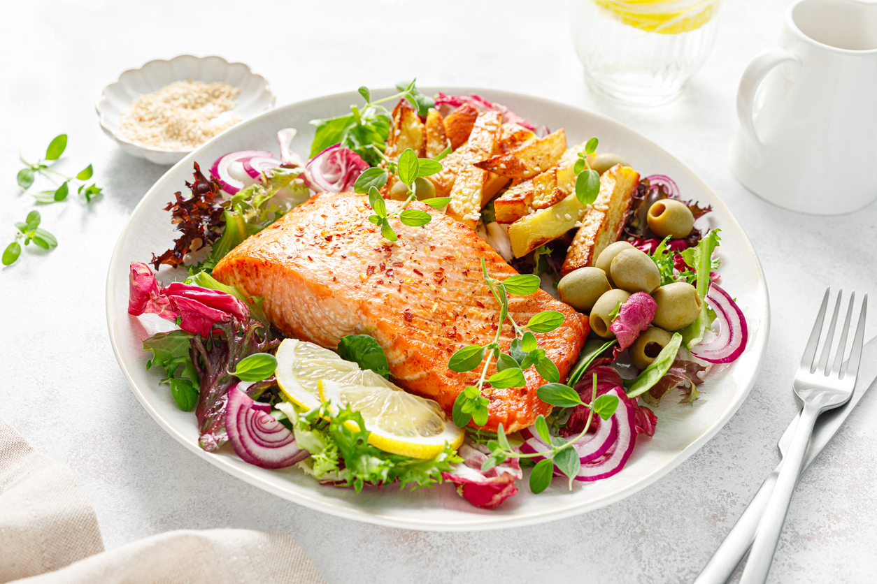 Salmon fillet grilled, fried potato and fresh vegetable green salad