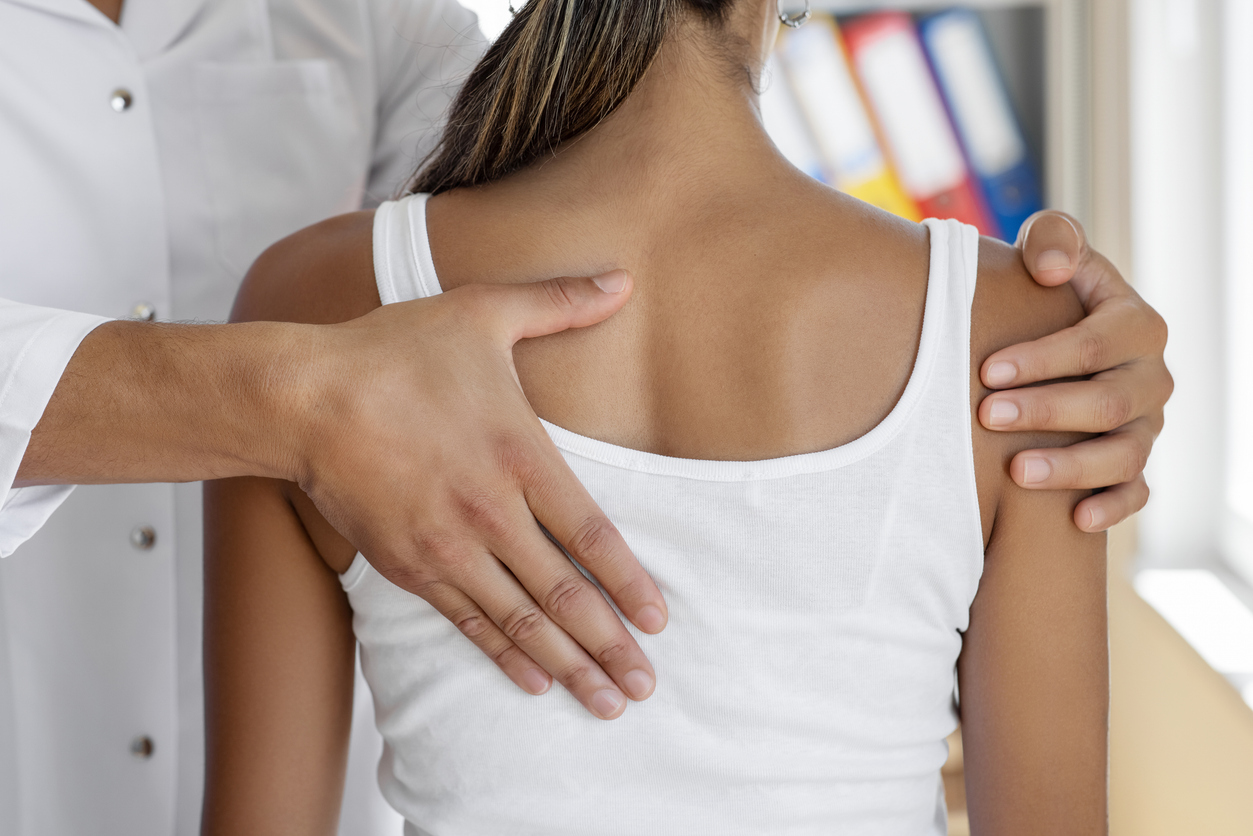 Doctor physiotherapist doing healing treatment on woman's back