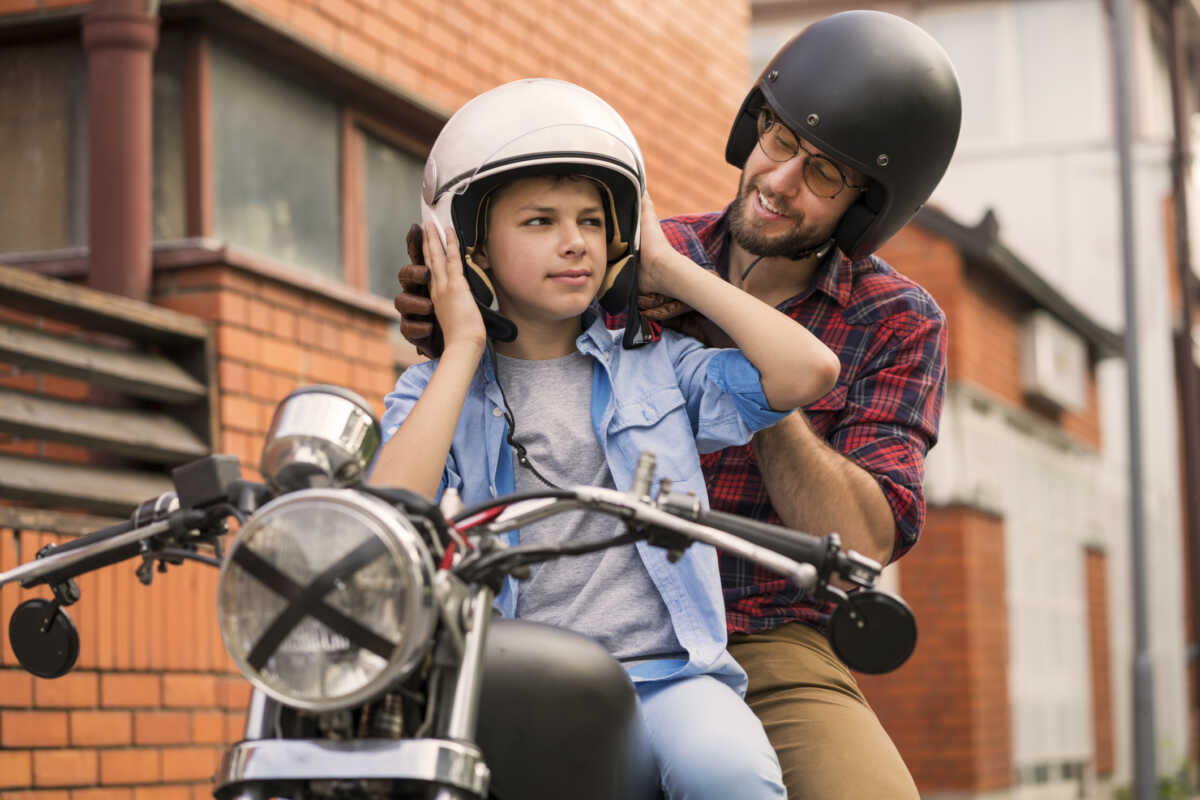 Teen boy with father and motorcycle