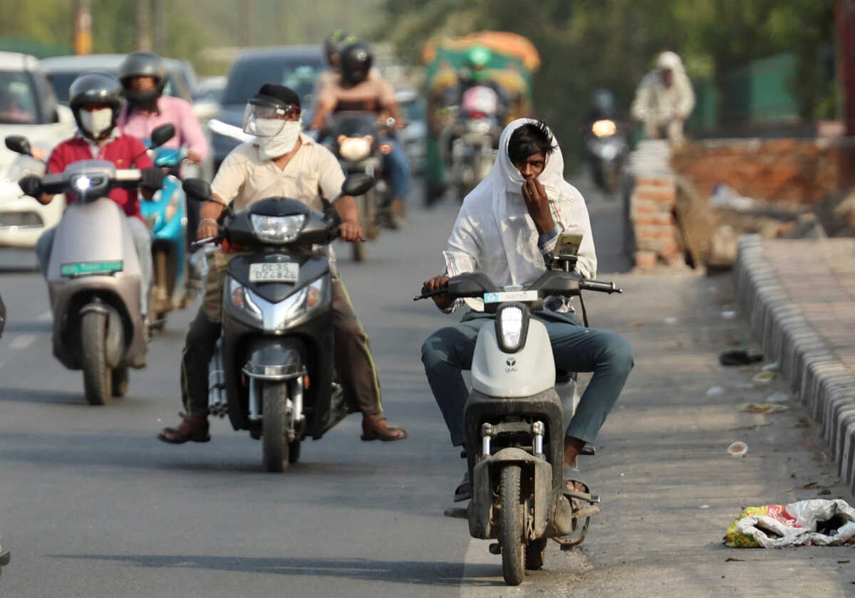 A delivery partner with Swiggy, an Indian online-delivery company, rides a low-speed two-wheeler electric vehicle on a bridge on a hot summer day, during a heatwave in New Delhi, India, May 31, 2024. REUTERS