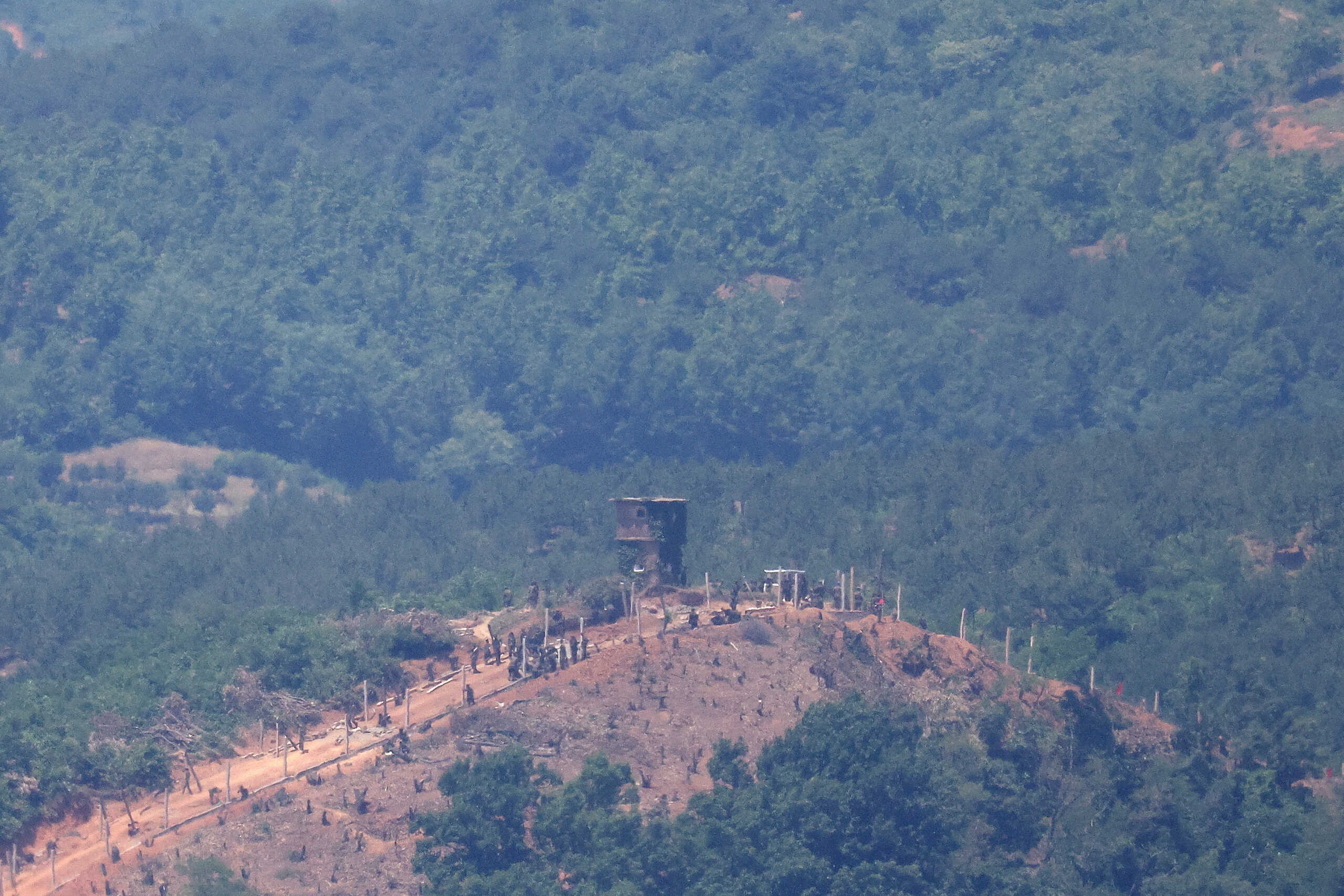 North Korean people work on a military fence near their guard post at the inter-Korean border in this picture taken from the observation deck near the demilitarized zone that separates the two Koreas in Paju, South Korea, June 4, 2024.    REUTERS