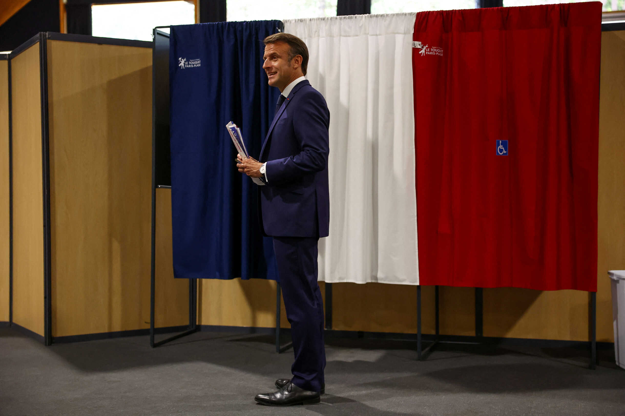 French President Emmanuel Macron stands in front of voting booths during the European Parliament election, at a polling station in Le Touquet-Paris-Plage, France, June 9, 2024. REUTERS