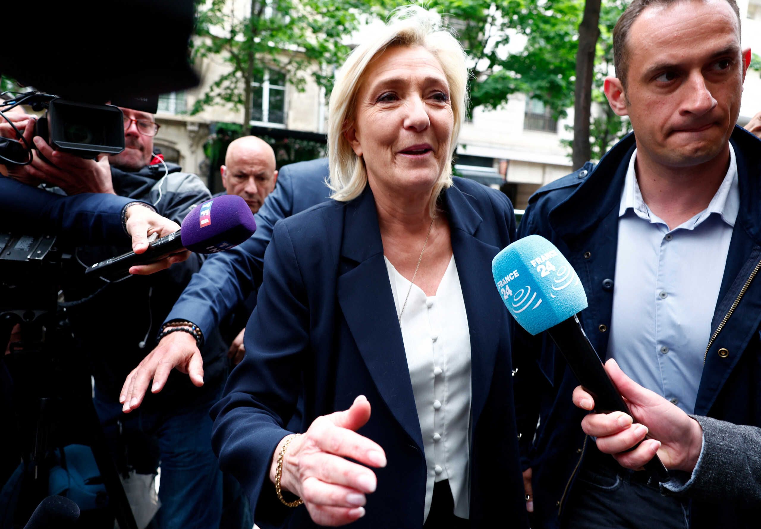 Marine Le Pen, President of the French far-right National Rally (Rassemblement National - RN) party parliamentary group, is surrounded by journalists as she arrives at the RN party headquarters in Paris, the day after French far-right win in European Parliament vote and the announcement of early legislative elections in France, June 10, 2024. REUTERS