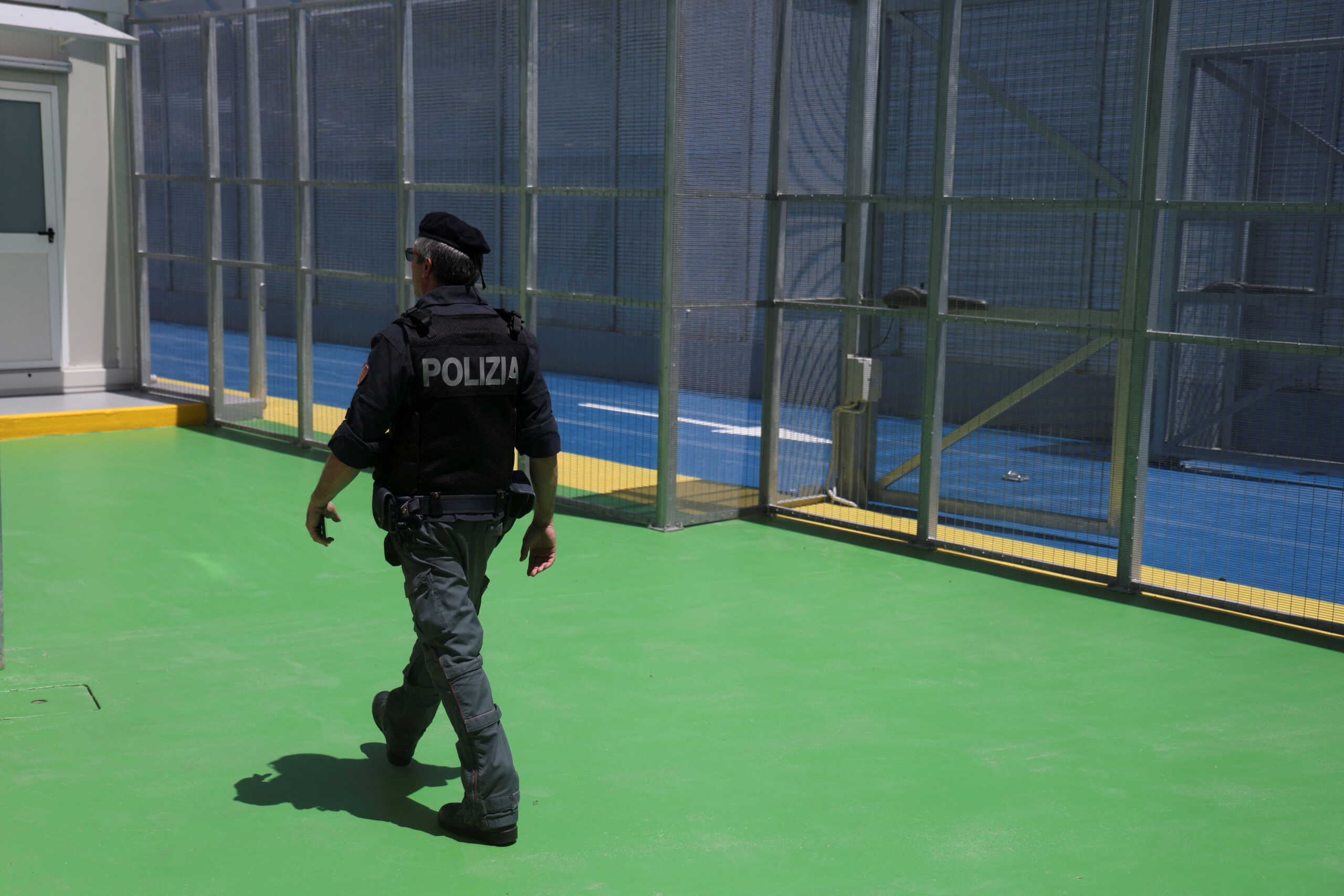 An Italian police officer walks at the reception camp at the port where Italy will process migrants, as Italy's Prime Minister Giorgia Meloni visits the sites, in Shengjin, Albania June 5, 2024. REUTERS