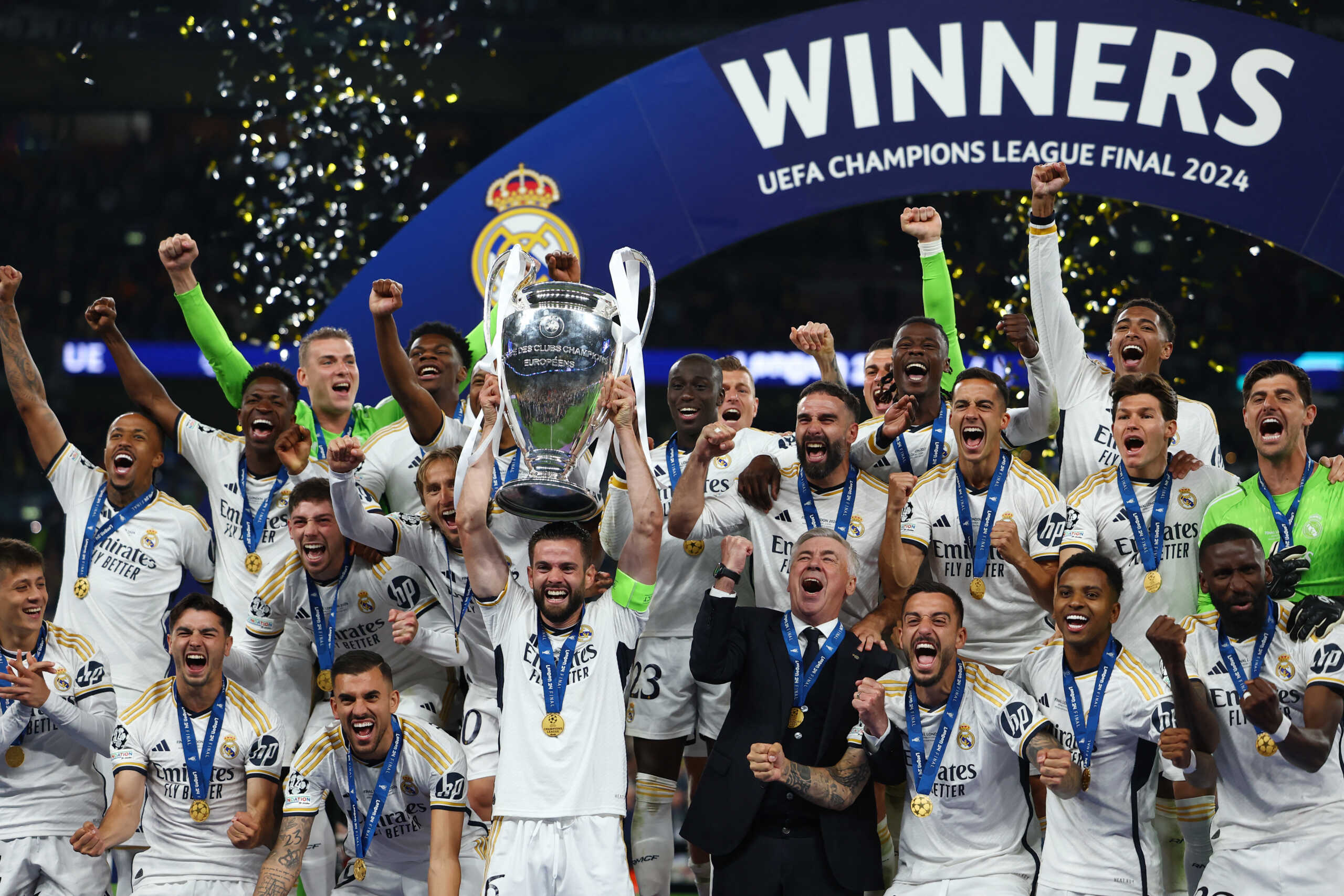 Soccer Football - Champions League - Final - Borussia Dortmund v Real Madrid - Wembley Stadium, London, Britain - June 1, 2024 Real Madrid's Dani Carvajal lifts the trophy as he celebrates with teammates and coach Carlo Ancelotti after winning the Champions League REUTERS