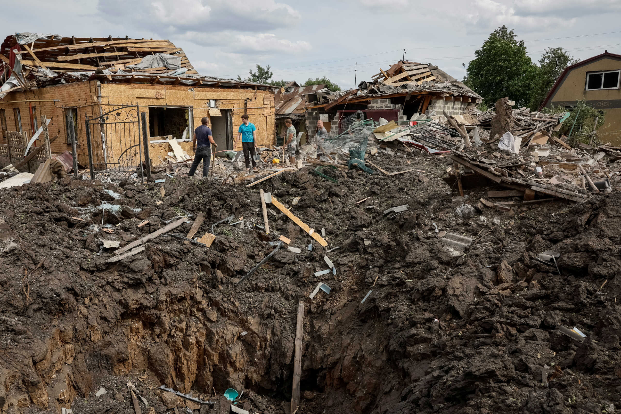 People stand near destroyed residential buildings at a site of a Russian missile strike, amid Russia's attack on Ukraine, in Pokrovsk, Donetsk region Ukraine June 24, 2024. REUTERS