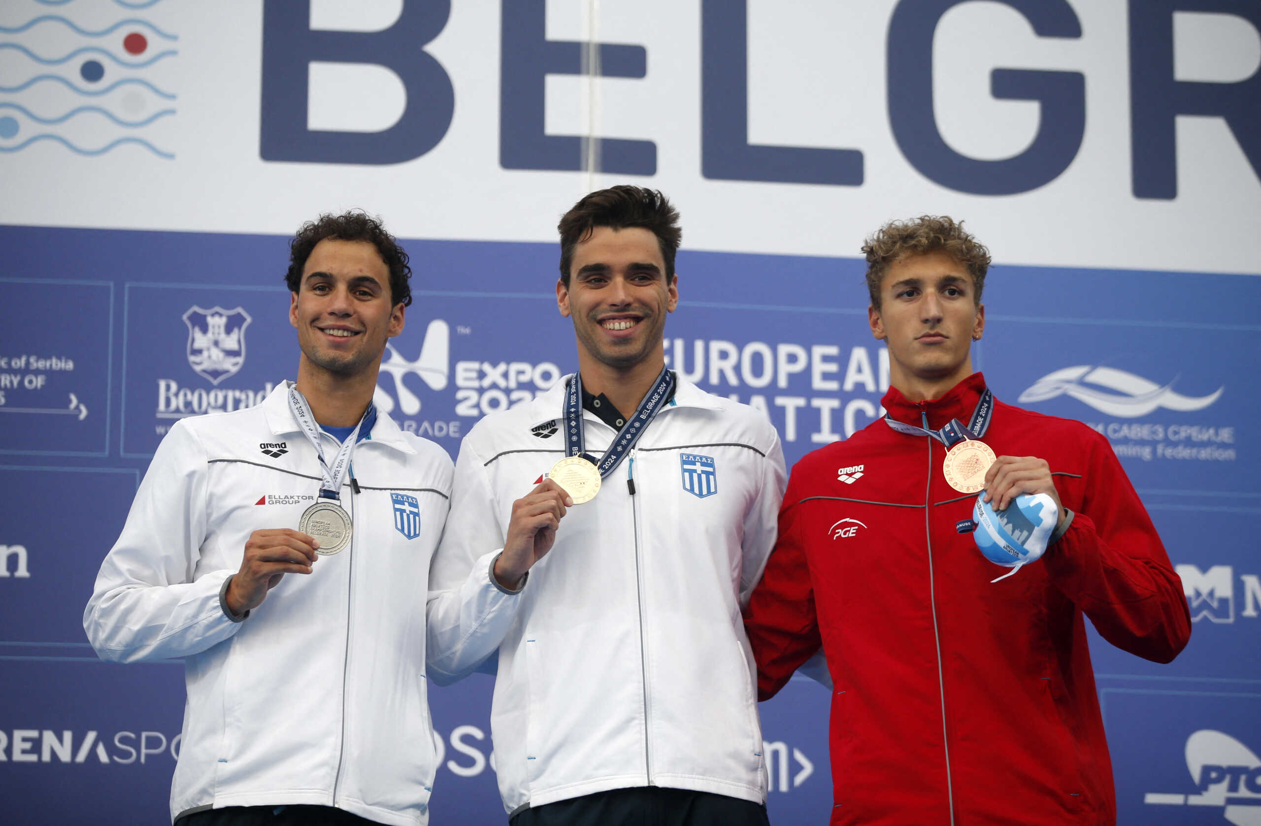 Swimming - European Aquatics Championships - Sports and Recreational Center Milan Gale Muskatirovic, Belgrade, Serbia - June 23, 2024 Gold medallist Greece's Apostolos Christou poses with his medal on the podium after winning the men's 100m backstroke final with silver medallist Greece's Evangelos Makrygiannis and bronze medallist Poland's Ksawery Masiuk REUTERS
