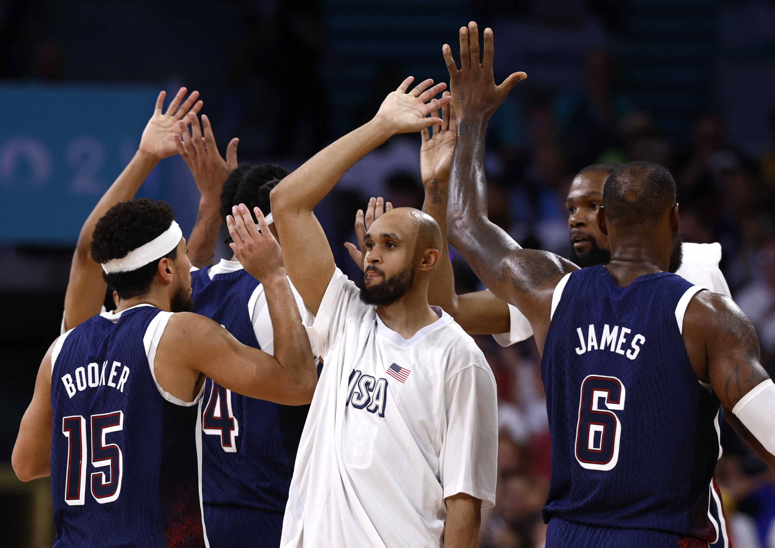 Paris 2024 Olympics - Basketball - Men's Group Phase - Group C - Serbia vs United States of America - Lille, Pierre Mauroy Stadium, Villeneve-d'Ascq, France - July 28, 2024. Derrick White of United States, Devin Booker of United States, Kevin Durant of United States and Lebron James of United States celebrate REUTERS